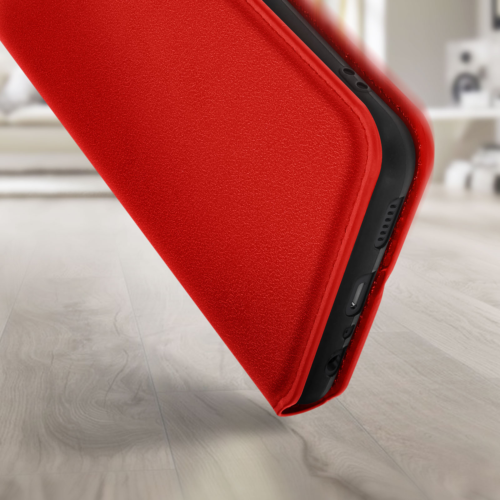 Custodia per telefono rossa, vista ravvicinata, su una superficie di legno, che mostra il bordo e una parte del telefono.