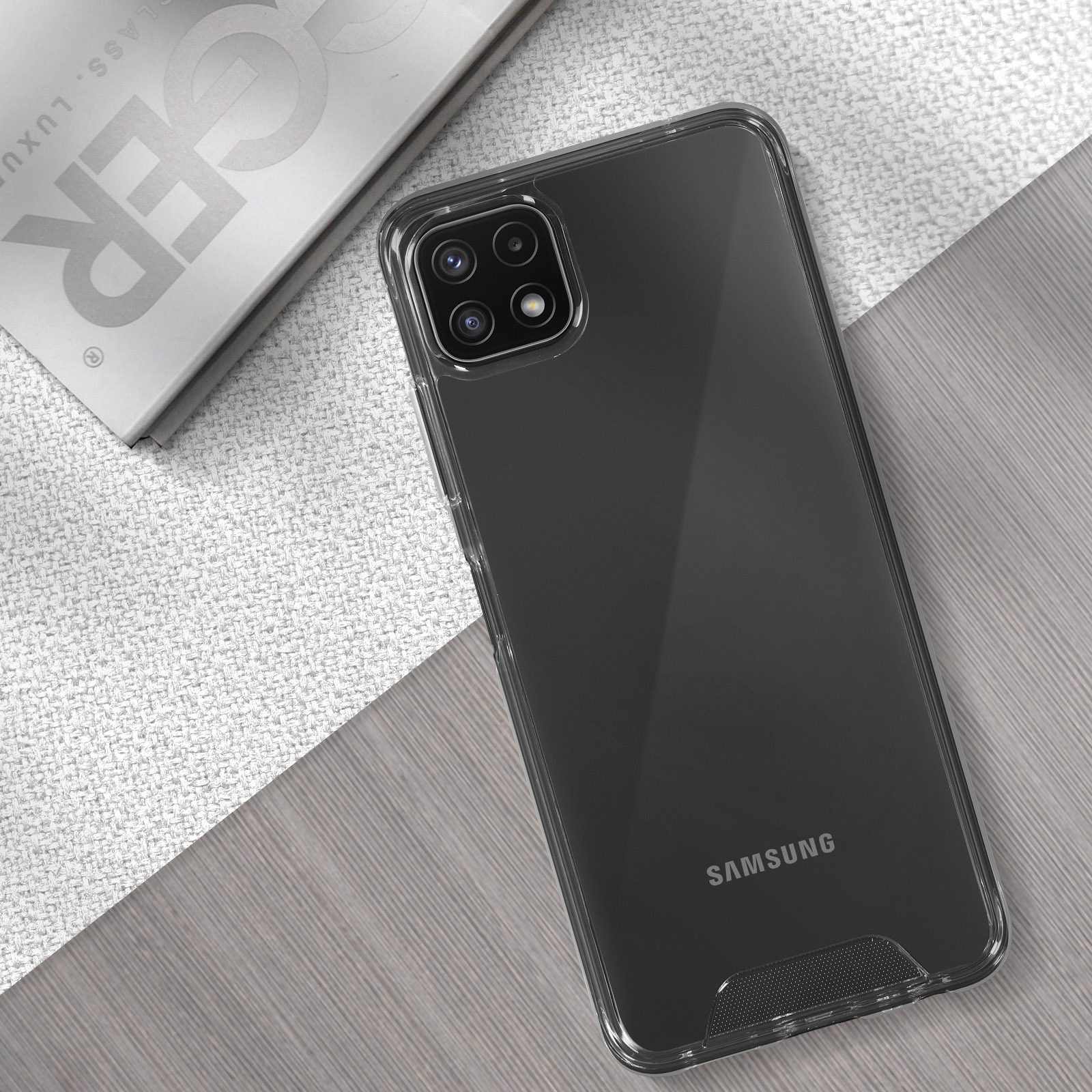 Una custodia trasparente per telefono su un telefono Samsung, con uno sfondo grigio e bianco.