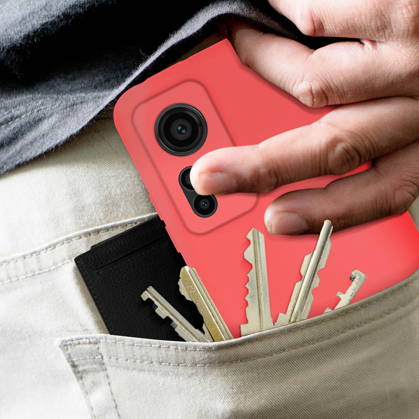Una custodia per telefono rossa in tasca, con chiavi e un porta carte nero visibili.