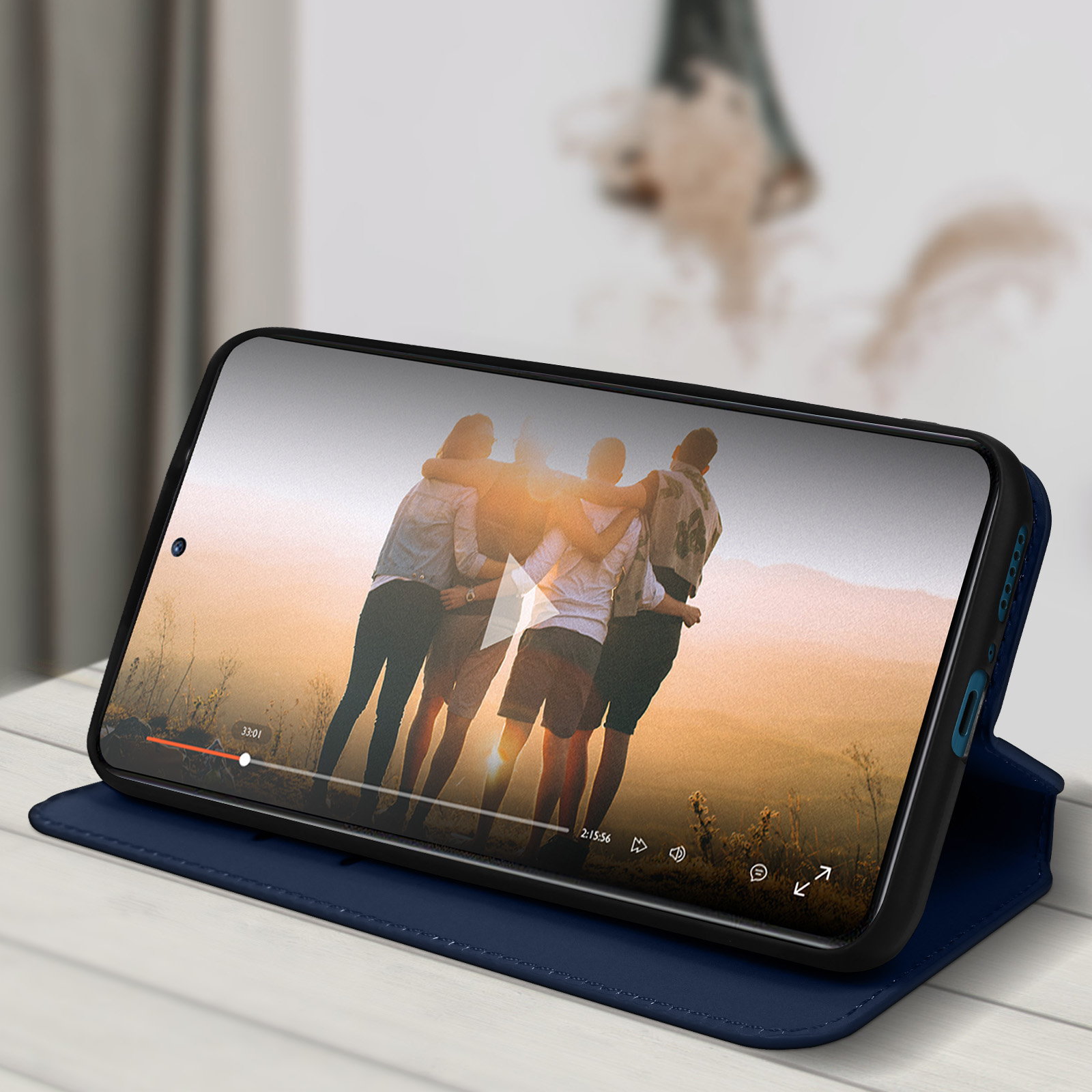 Ein Telefon zeigt ein Video von sich umarmenden Personen. Es ist in einem blauen Gehäuse und ist geöffnet.