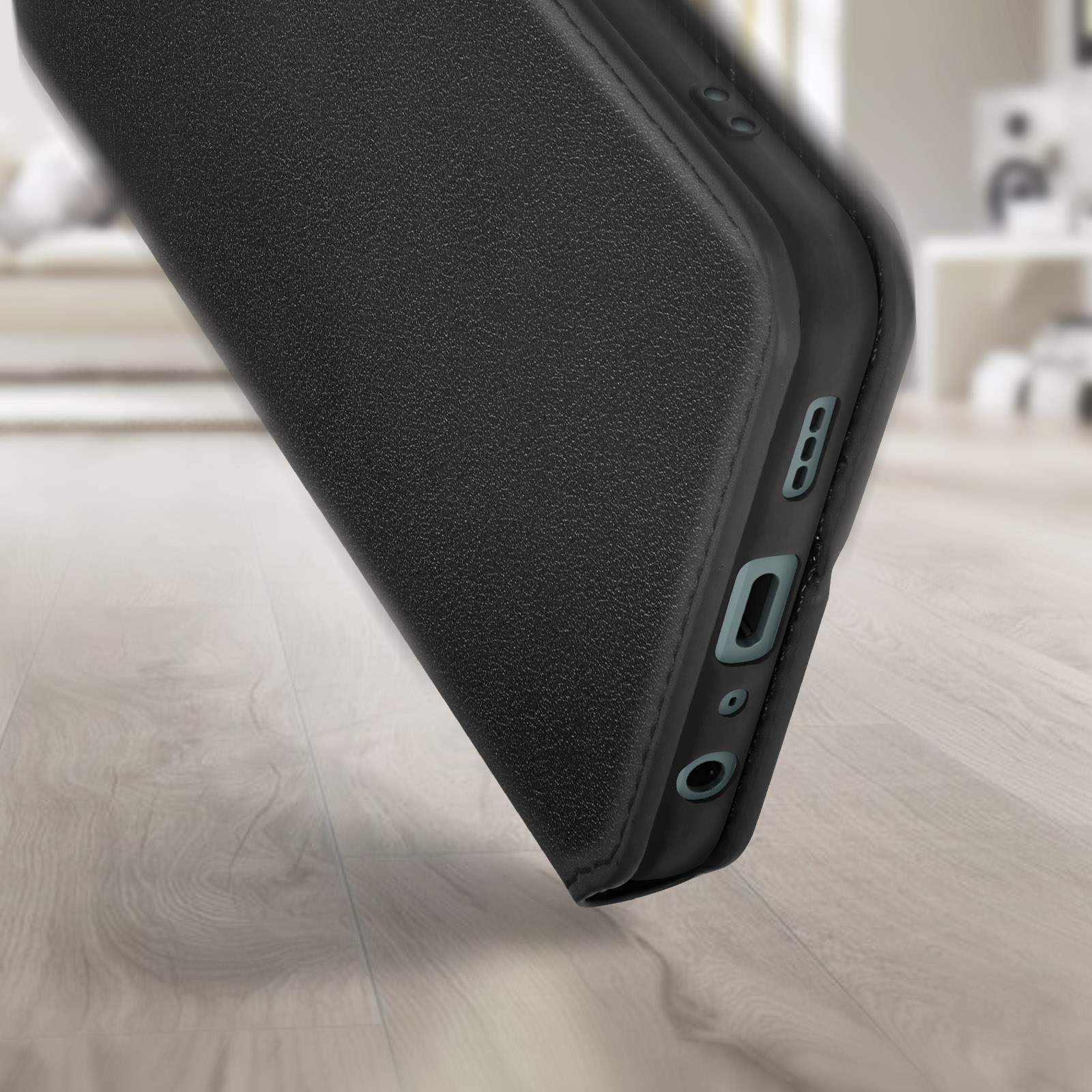 Primo piano di un telefono nero in una custodia nera, che mostra la porta di ricarica e gli altoparlanti.