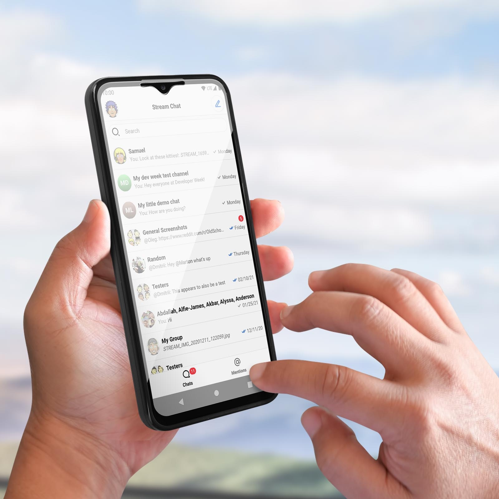 Persona che tiene in mano un telefono nero, che mostra l'interfaccia di un'app di chat. Lo schermo mostra i messaggi.