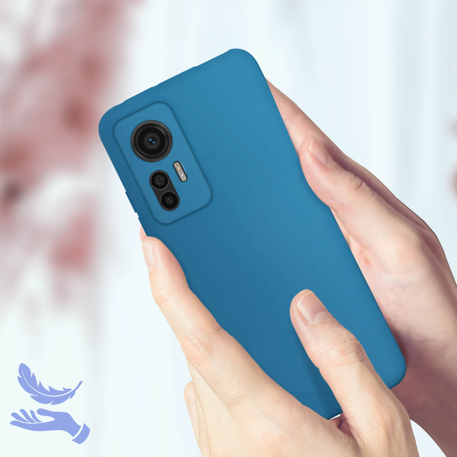 Un telefono in una custodia blu tenuto in mano. Lo sfondo è un ambiente chiaro e sfocato.