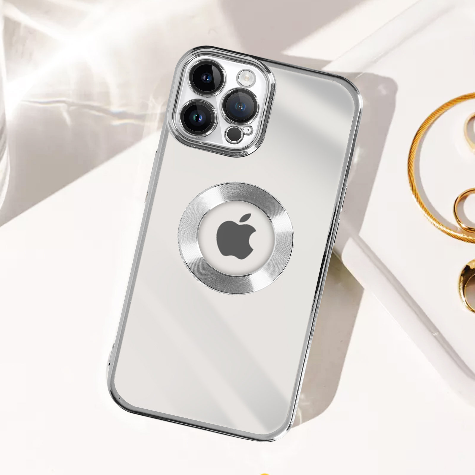Custodia argentata per telefono con fotocamere. Logo Apple sul retro. Su superficie bianca.