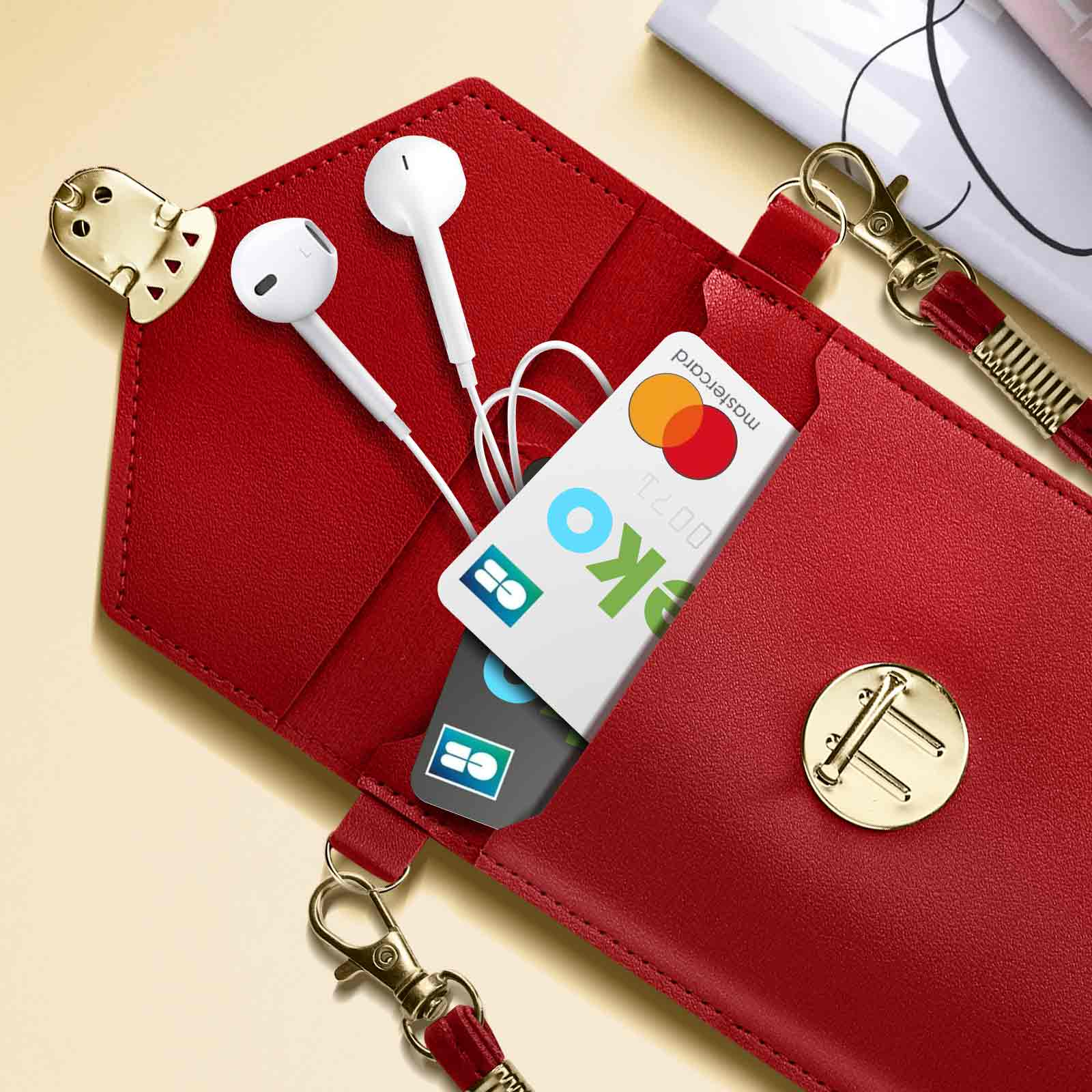 Custodia rossa per telefono con Mastercard e auricolari all'interno.
