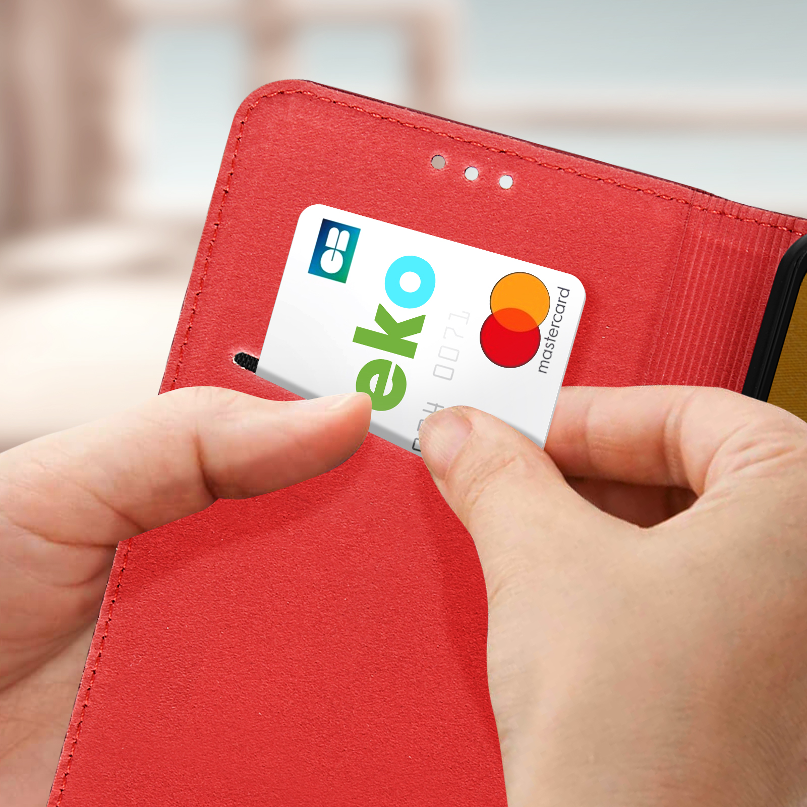 Una mano inserisce una carta in una custodia rossa per telefono. La carta dice eko e Mastercard.