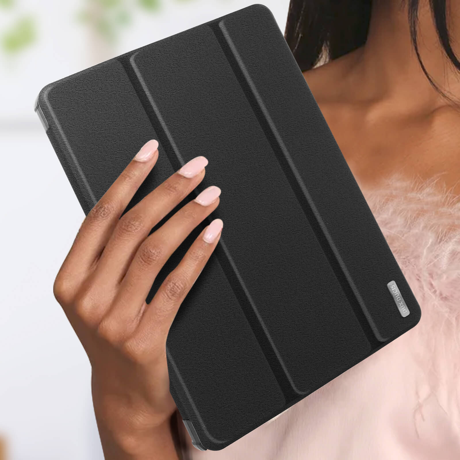 Eine Hand hält eine schwarze Tablet-Hülle. Die Hülle ist geschlossen und hat eine strukturierte Oberfläche.