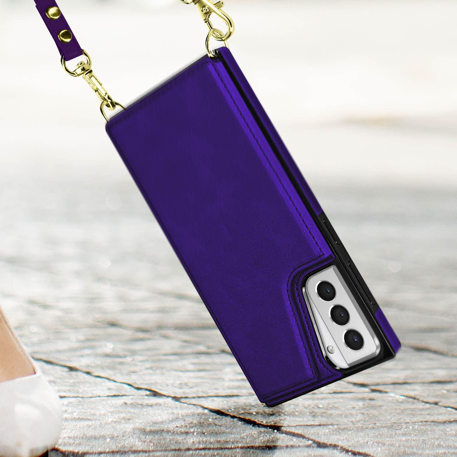 Custodia per telefono viola con cinturino. È appesa a una catena d'oro.