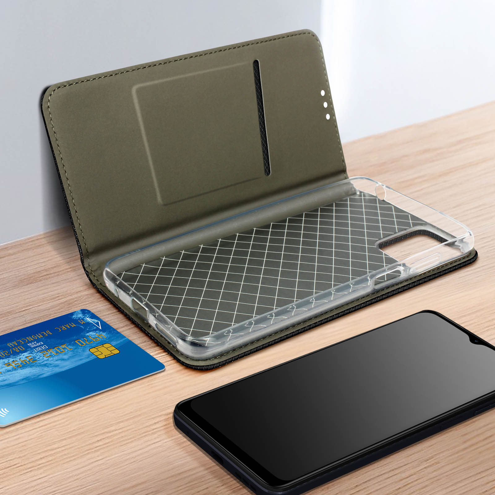 Telefon in offener grüner Hülle mit Kreditkarte. Schwarzes Telefon davor.