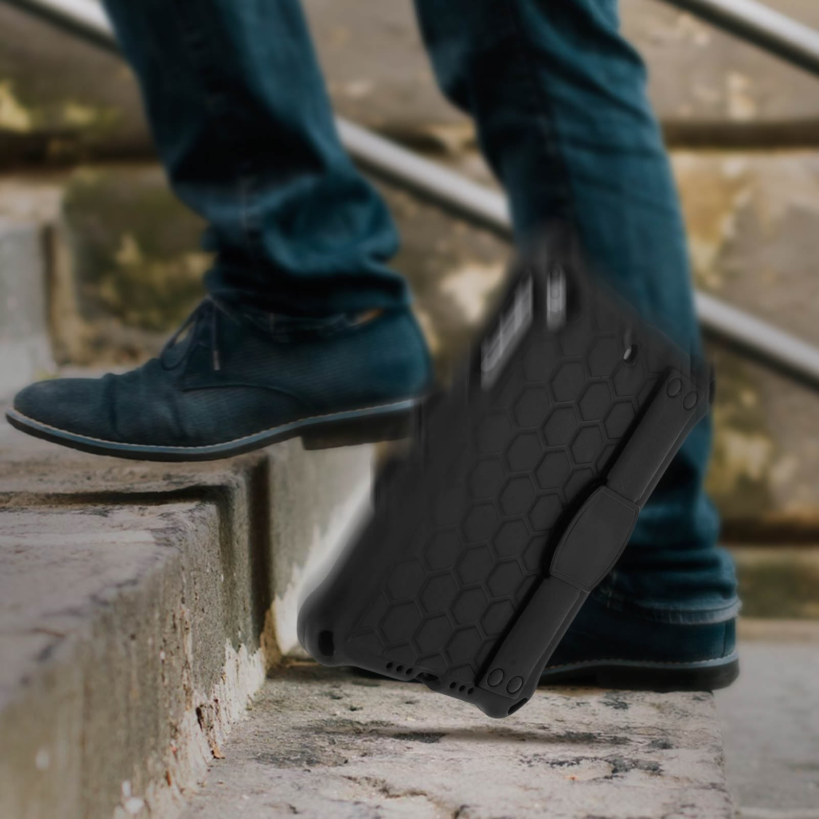 Eine Person geht eine Treppe hinunter mit einer Handyhülle. Die Handyhülle ist schwarz mit einem geometrischen Design.