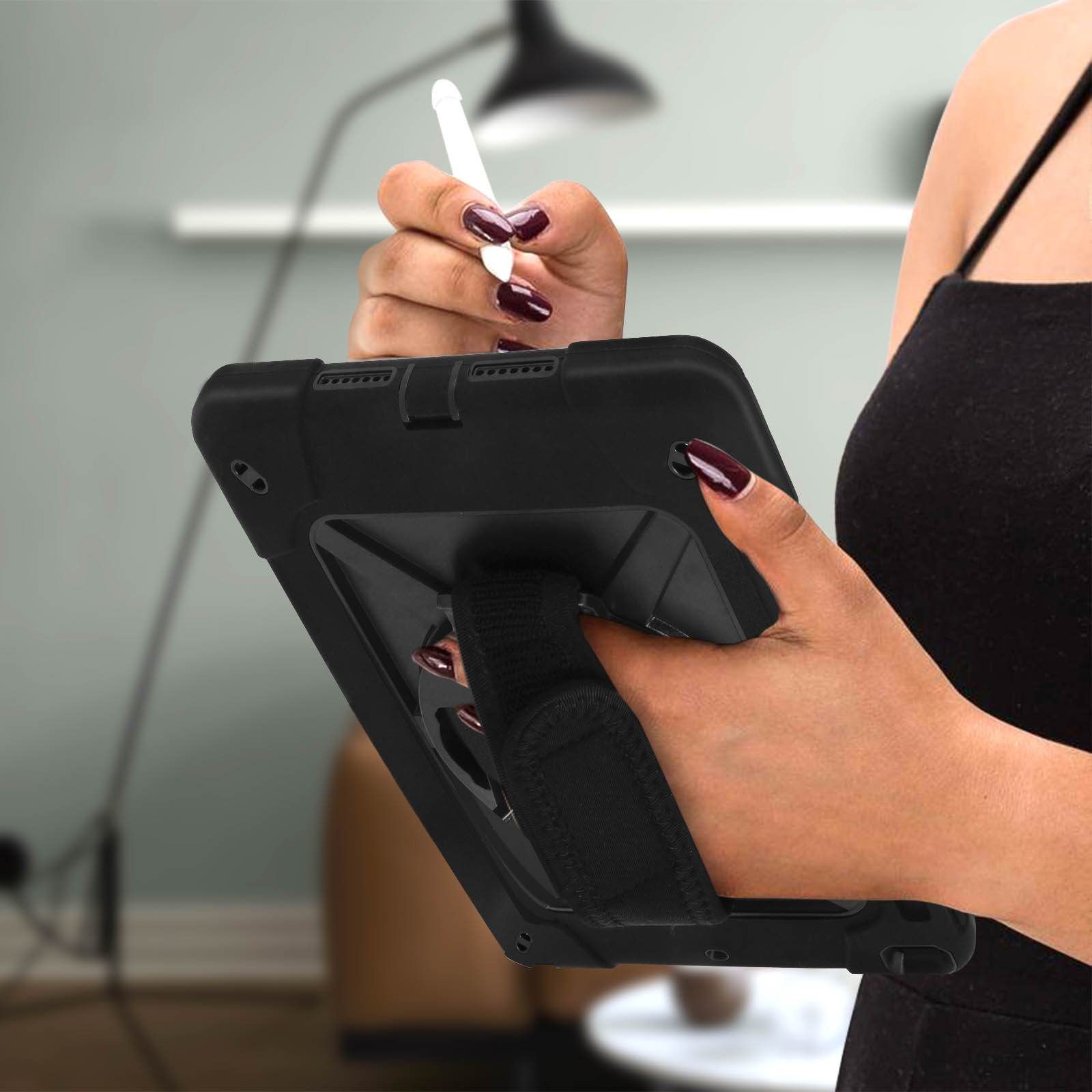 Eine Person hält ein schwarzes Tablet mit einem Stift. Das Tablet hat eine Handschlaufe.