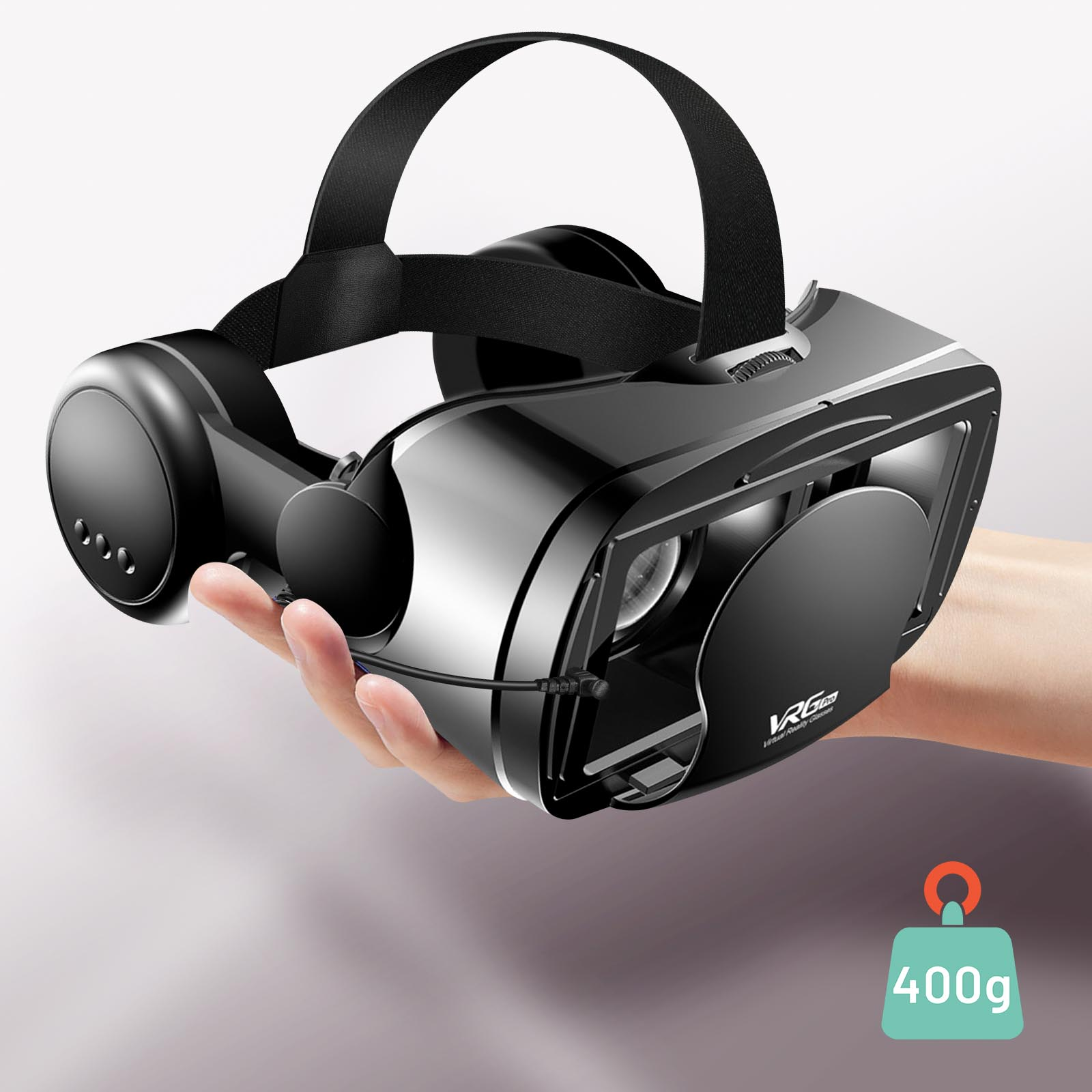 Gafas de realidad virtual negras sostenidas por una mano, con etiqueta de peso de 400g. Fondo blanco y negro.