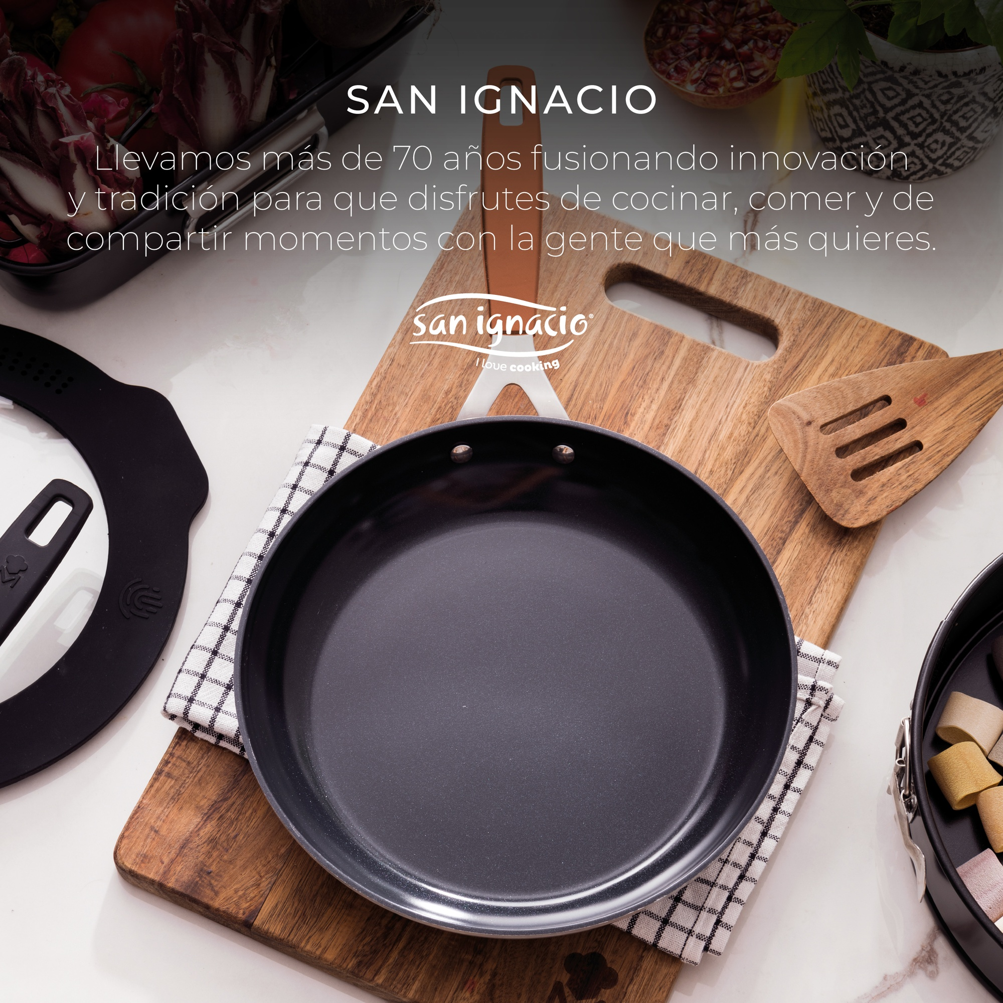 Sartén San Ignacio sobre tabla de madera con utensilios e ingredientes.