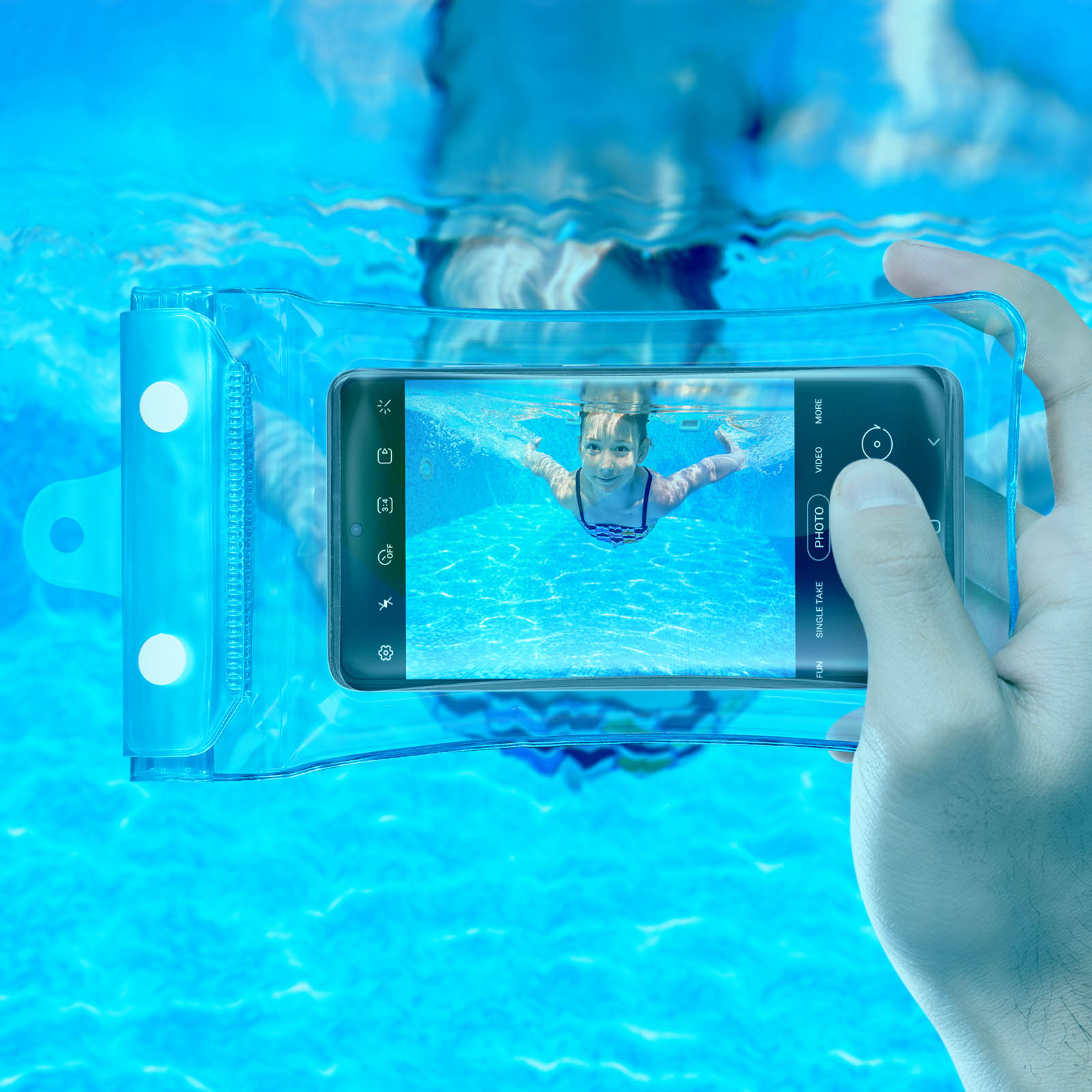 Una mano tiene un telefono in una custodia impermeabile, fotografando una ragazza che nuota.