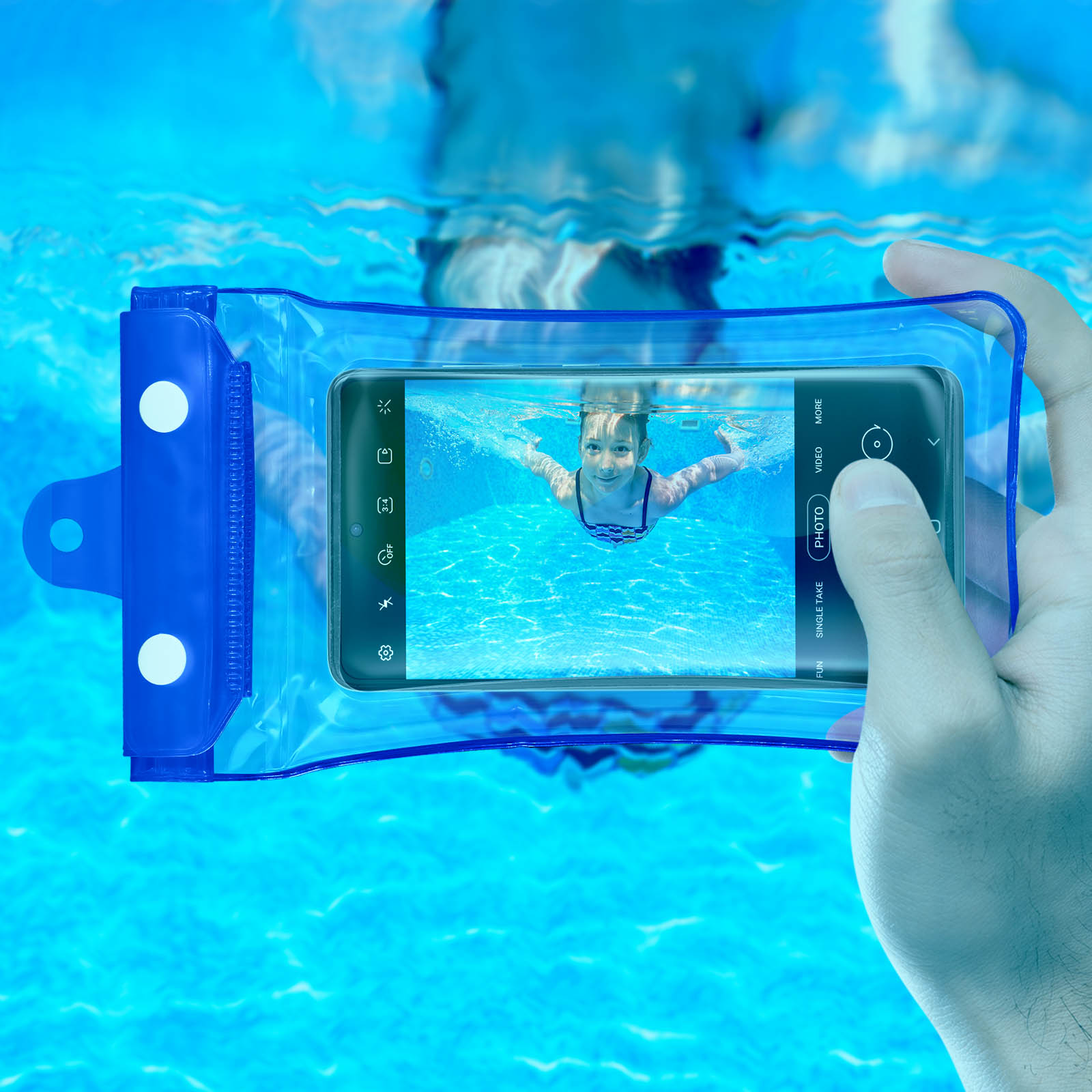 Ein Telefon in einer wasserdichten Hülle. Eine Person hält es. Ein Kind schwimmt im Hintergrund.