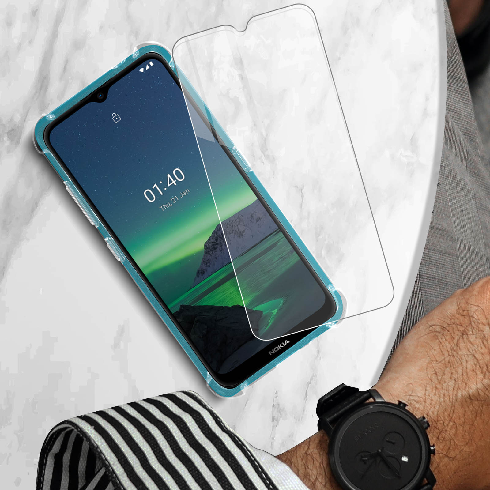 Telefono Nokia con protezione schermo, custodia turchese, su marmo con orologio.