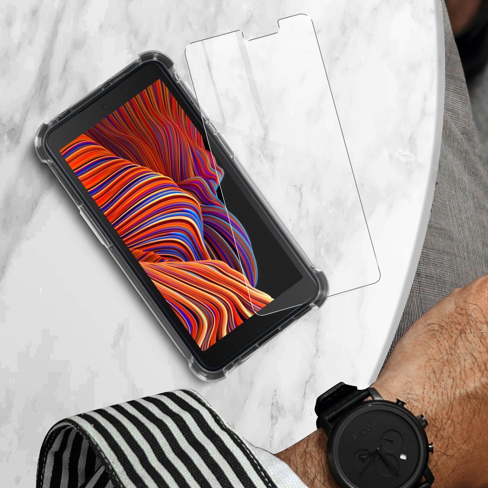 Telefono e protezione schermo su una superficie di marmo. Un orologio sulla destra.
