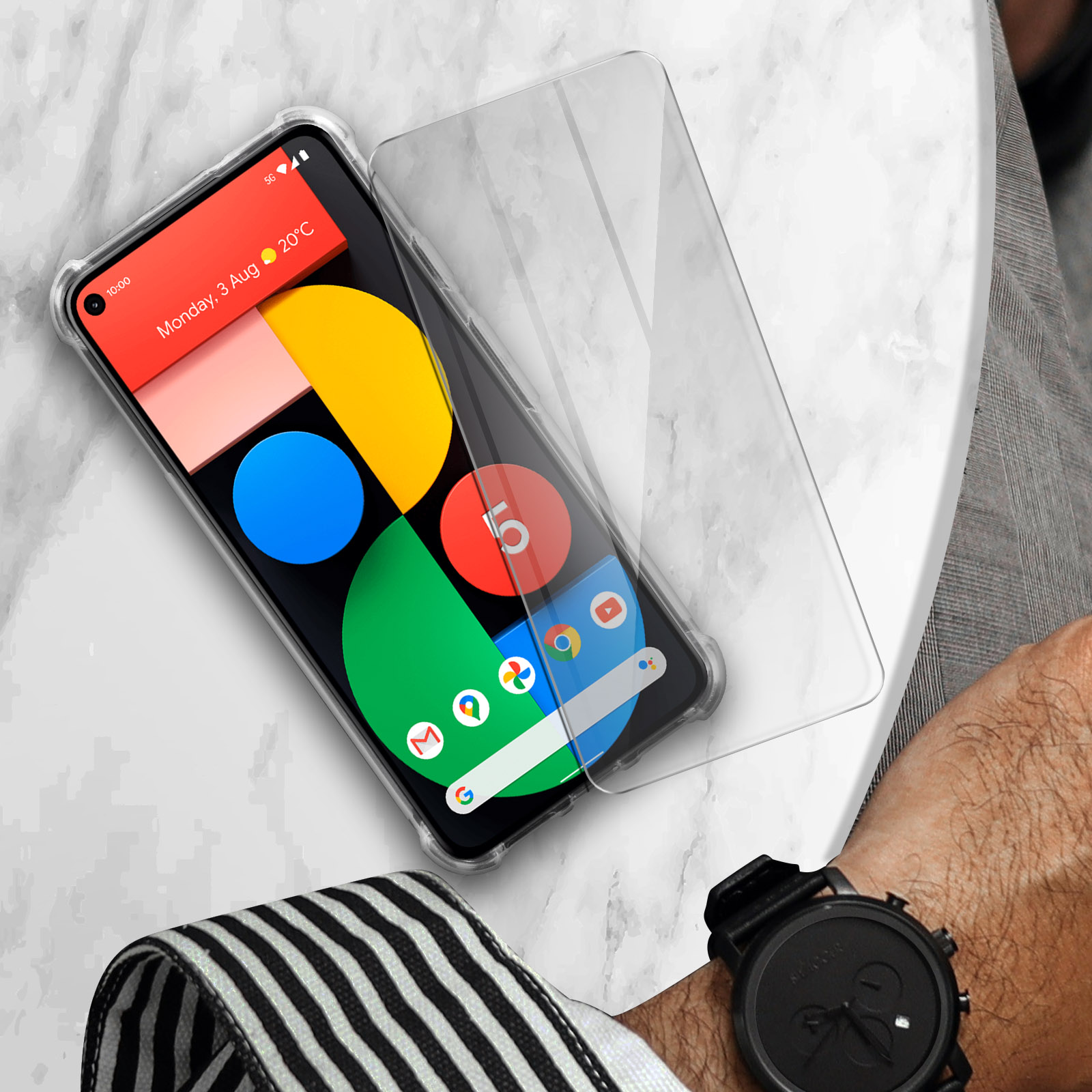 Telefono con protezione schermo applicata, mostra data e ora. Su un tavolo.