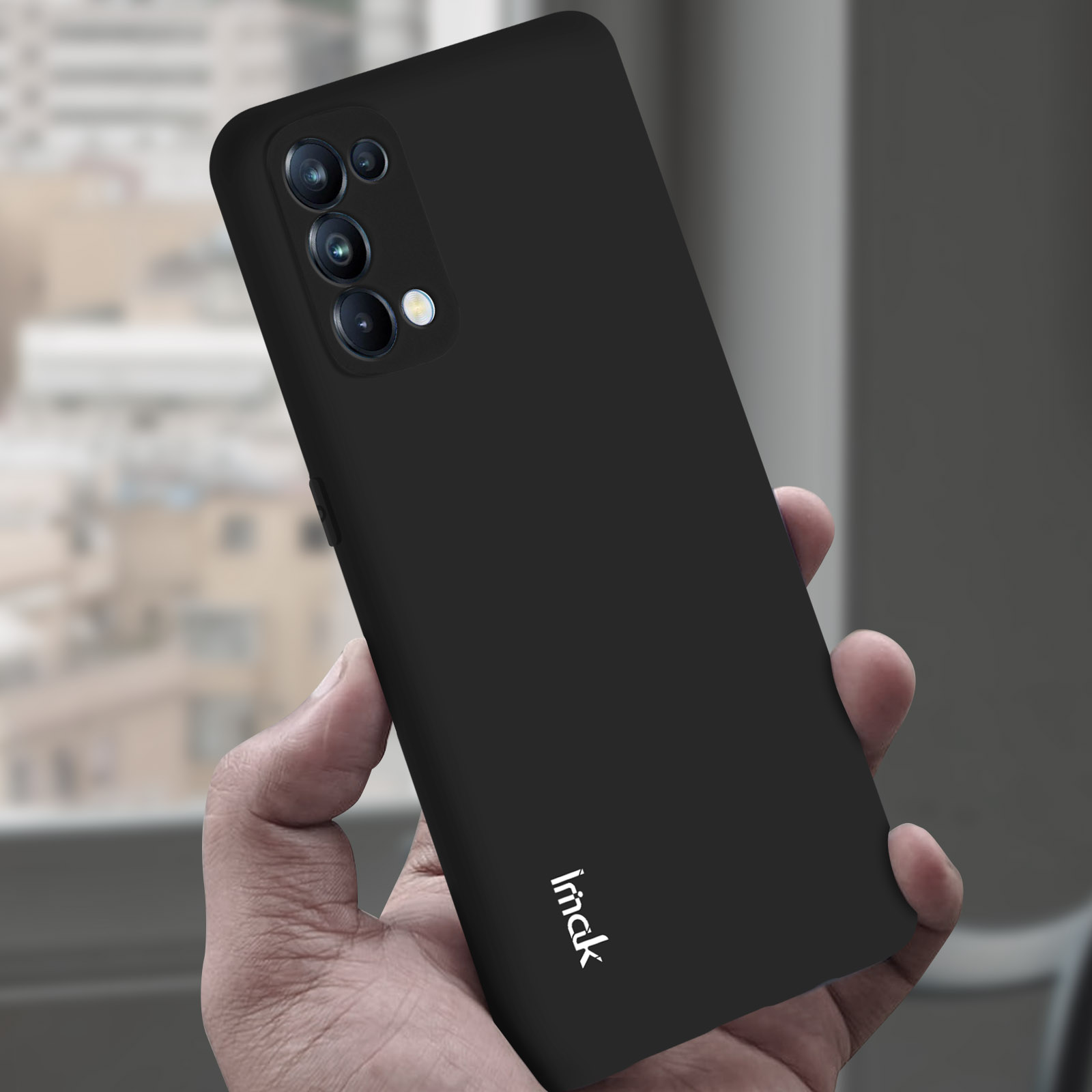 Una custodia nera per telefono tenuta in mano. Il telefono mostra più fotocamere. Marchio 'imack'.