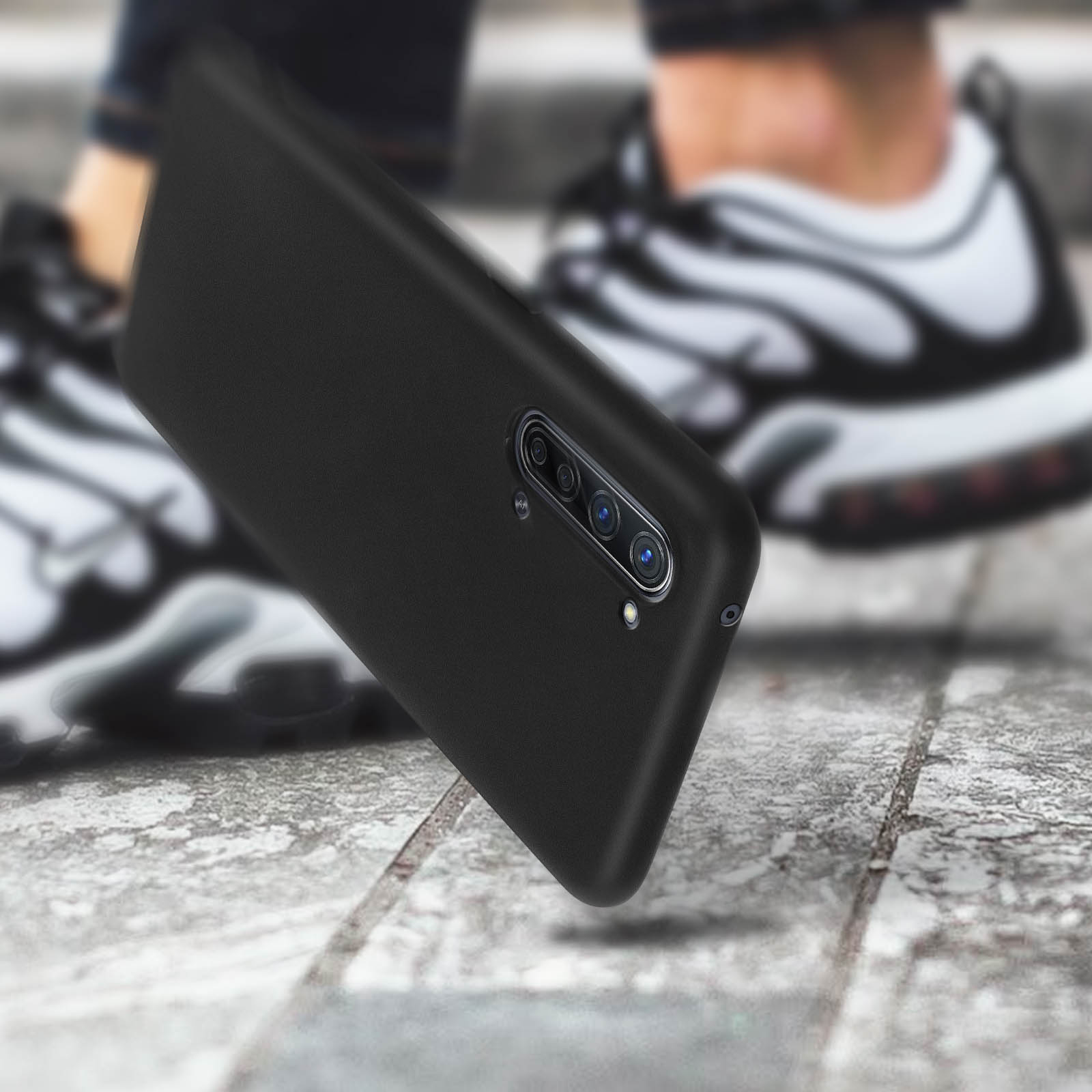 Téléphone noir dans une coque noire. Le téléphone est mis au point et incliné.