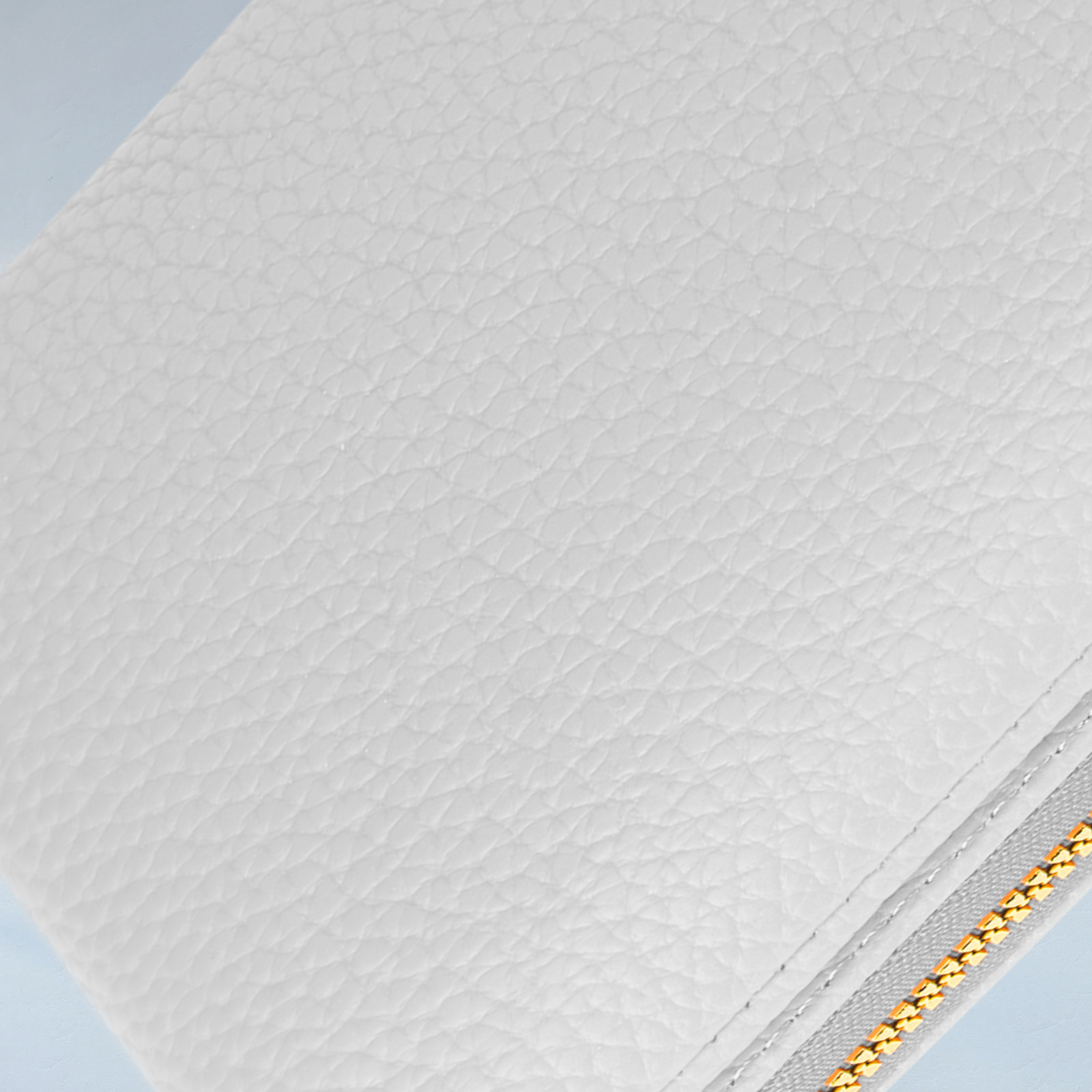 Witte leertextuur. Close-up van witte leertextuur. Gouden rits aan de rechterkant.