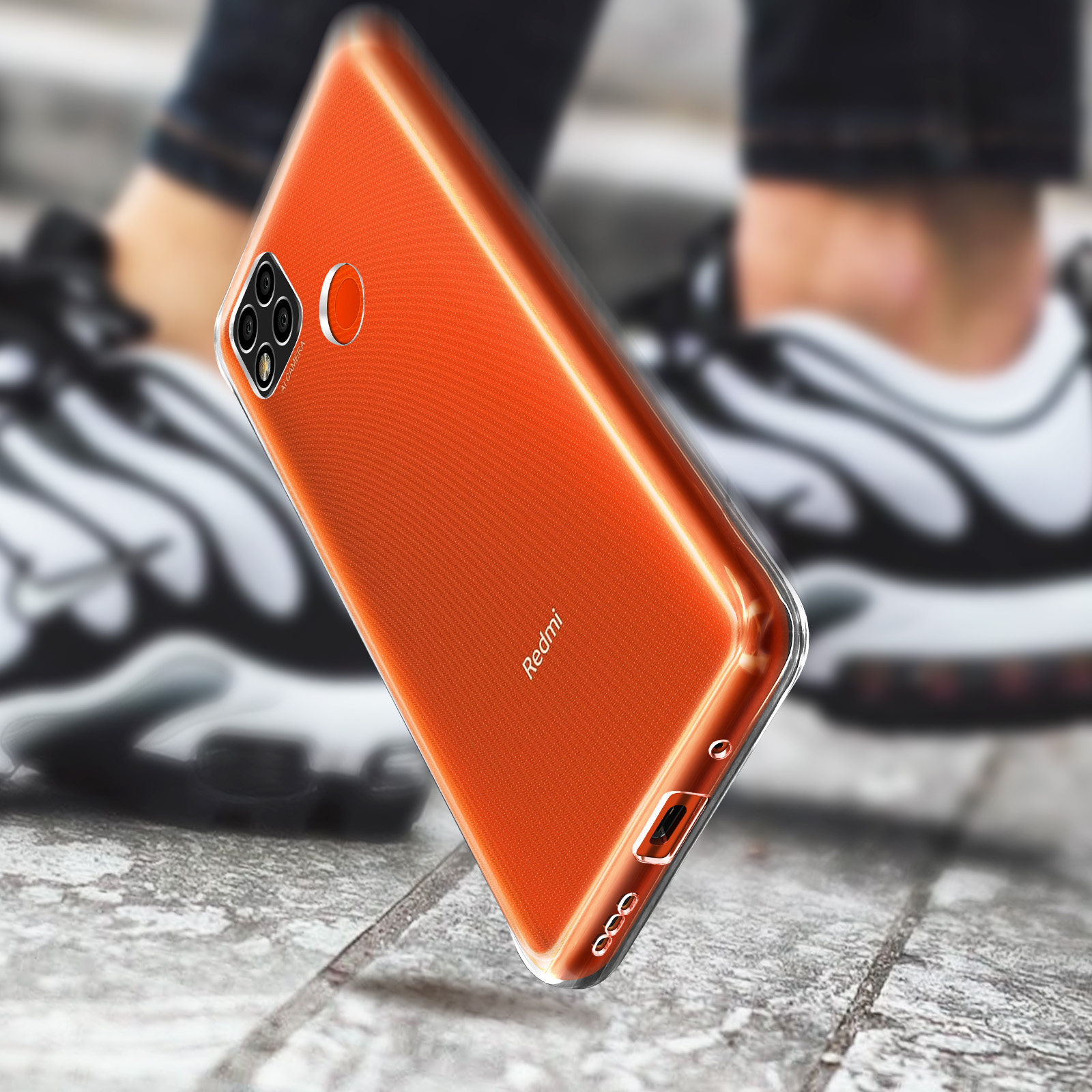 Téléphone orange avec étui transparent. Le téléphone repose sur une surface.