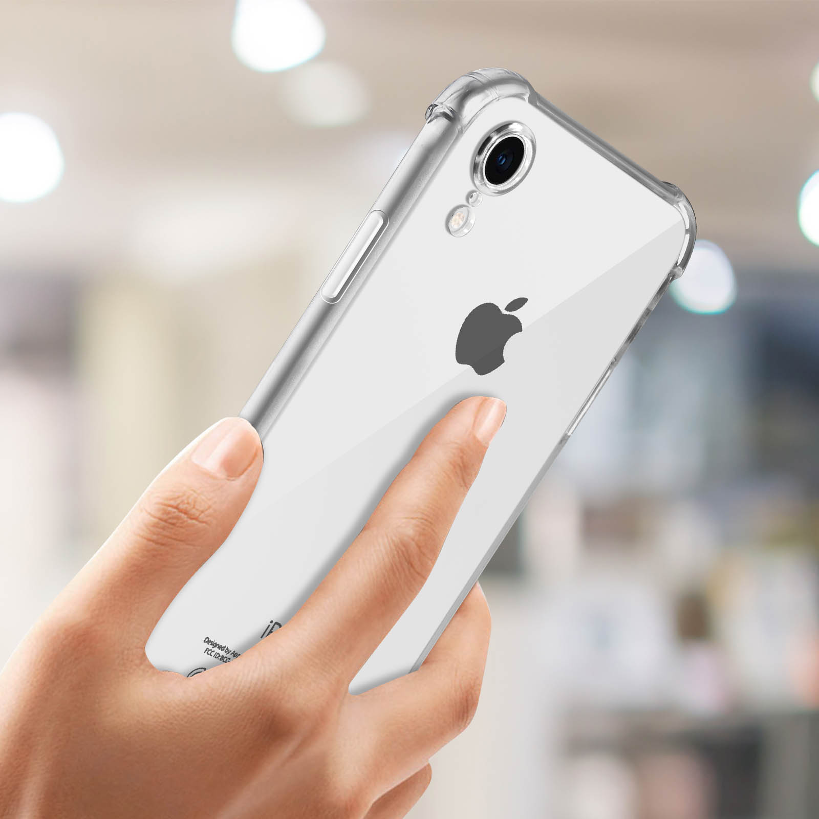 Mano che tiene una custodia trasparente con un iPhone all'interno, sfondo sfocato.