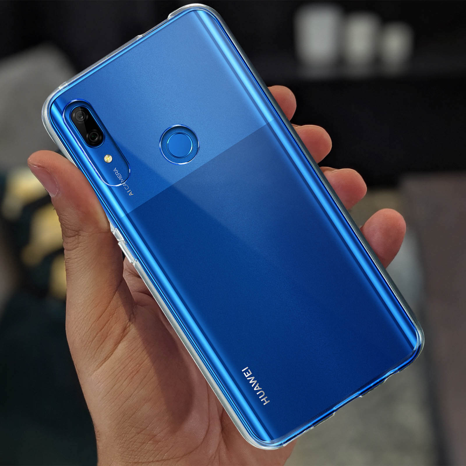 Une main tenant une coque de téléphone bleue avec une bordure transparente.