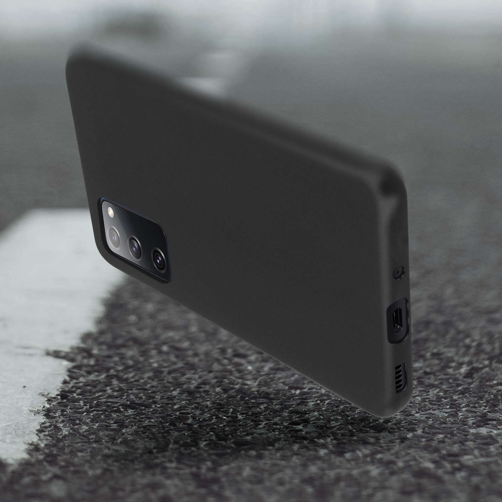Zwarte telefoonhoes, onder een hoek, op een ruw oppervlak. Camera zichtbaar.