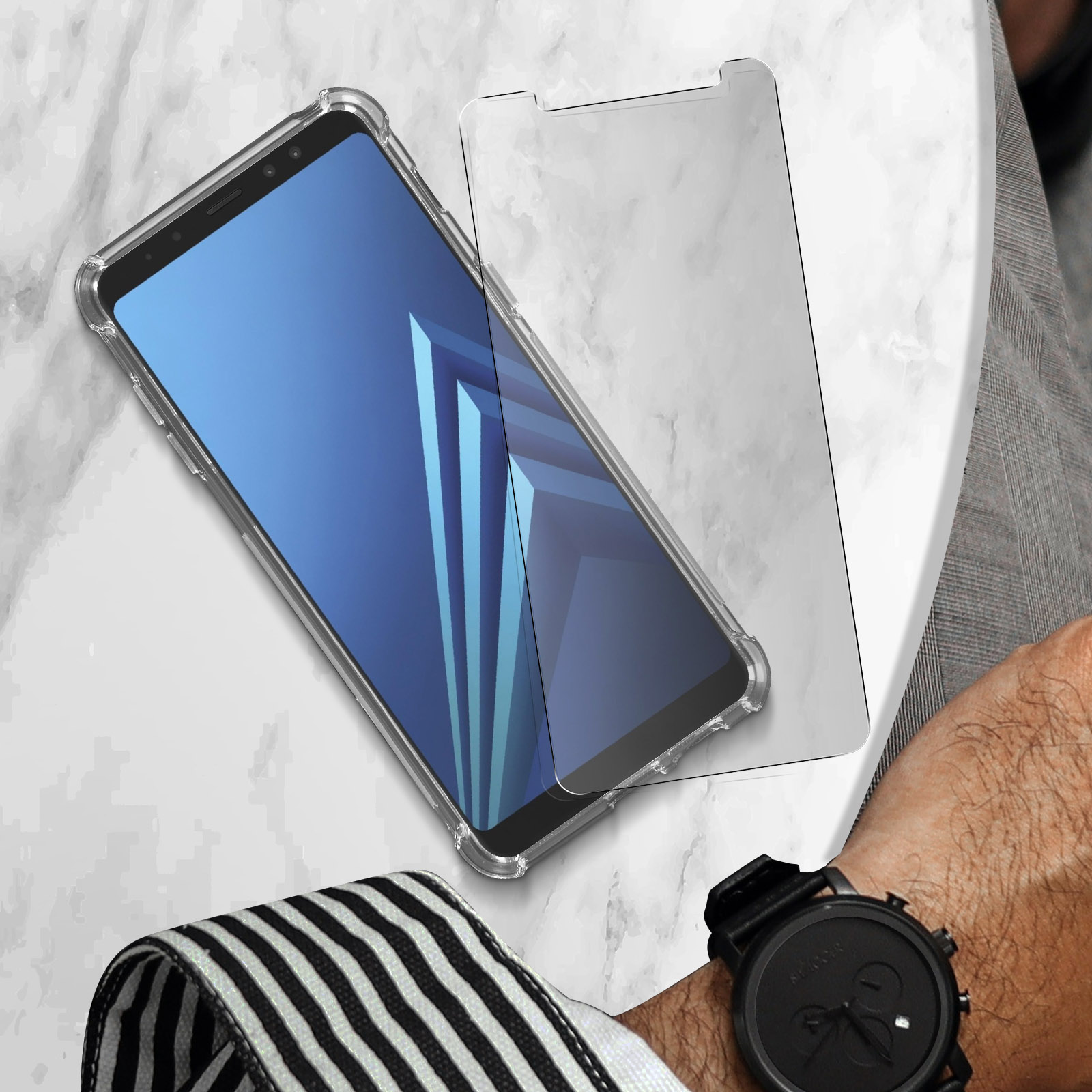 Smartphone in una custodia trasparente con protezione schermo, appoggiato su una superficie di marmo.