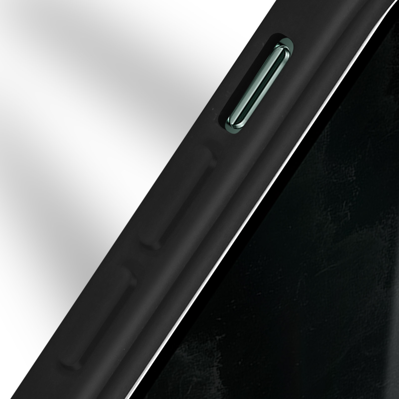 Gros plan sur le bord d'un téléphone noir avec un bouton sur fond blanc.