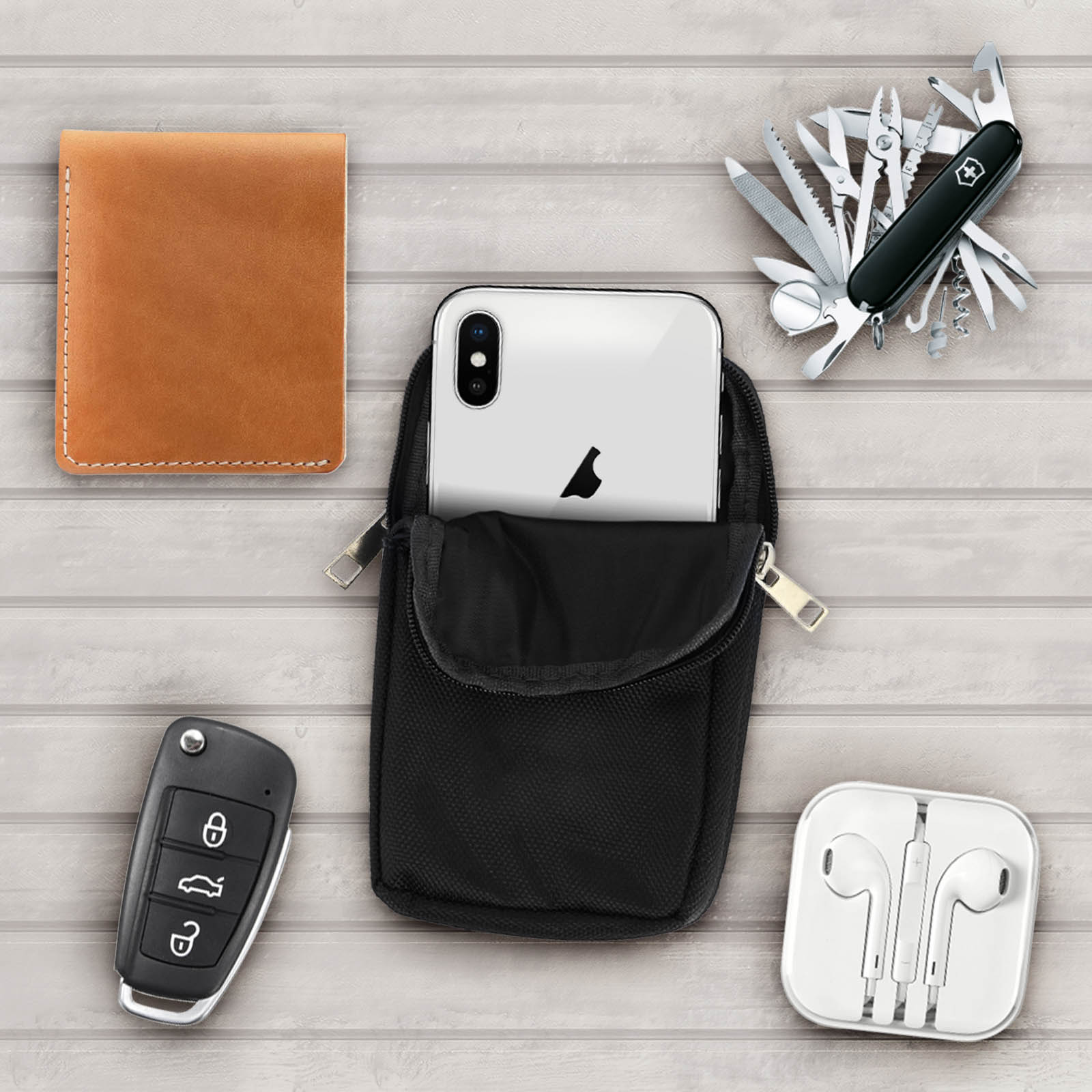Telefono in una borsa nera con altri accessori, tra cui portafoglio, chiavi e auricolari.
