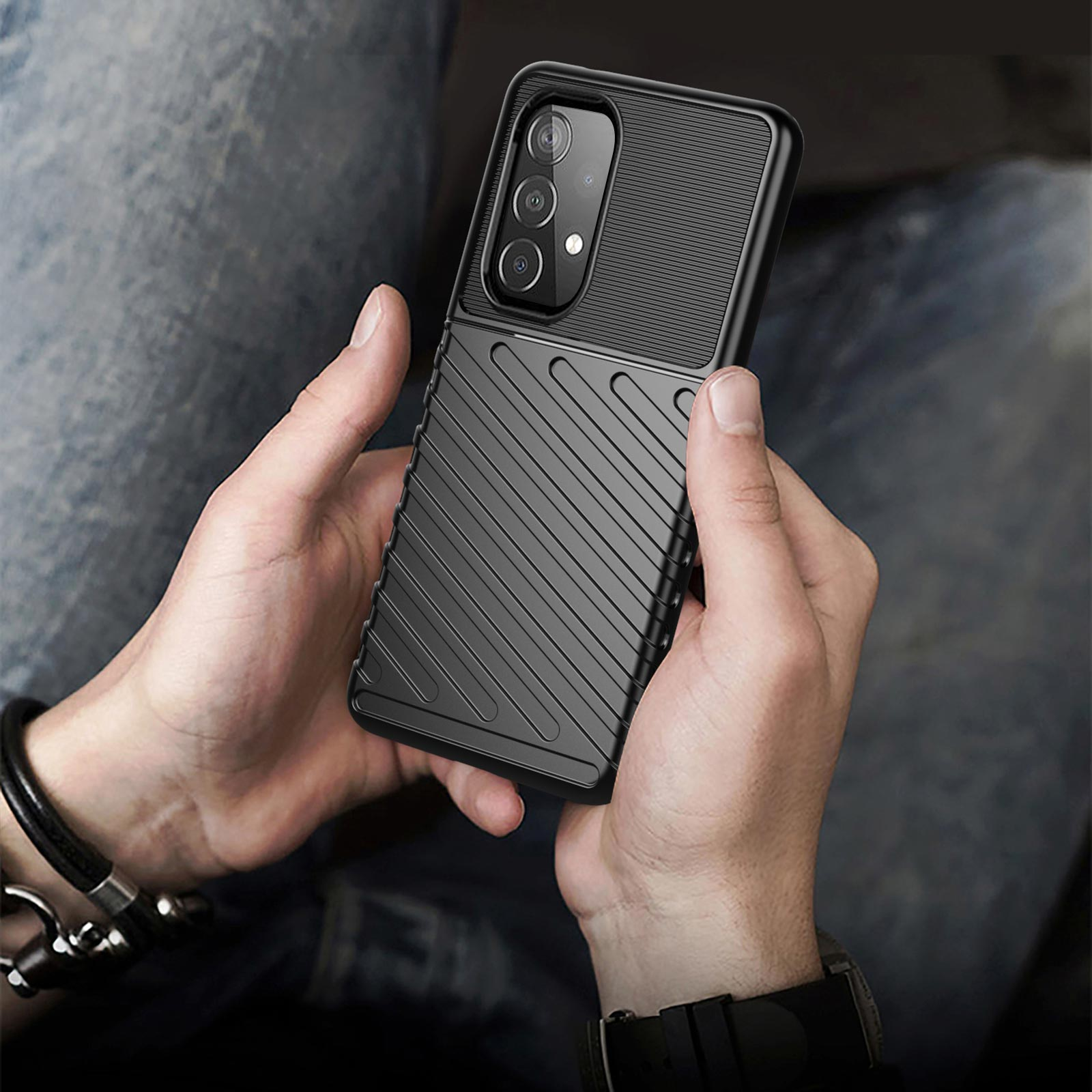 Custodia nera per telefono tenuta in mano. La custodia ha un design strutturato con più fori per la fotocamera.