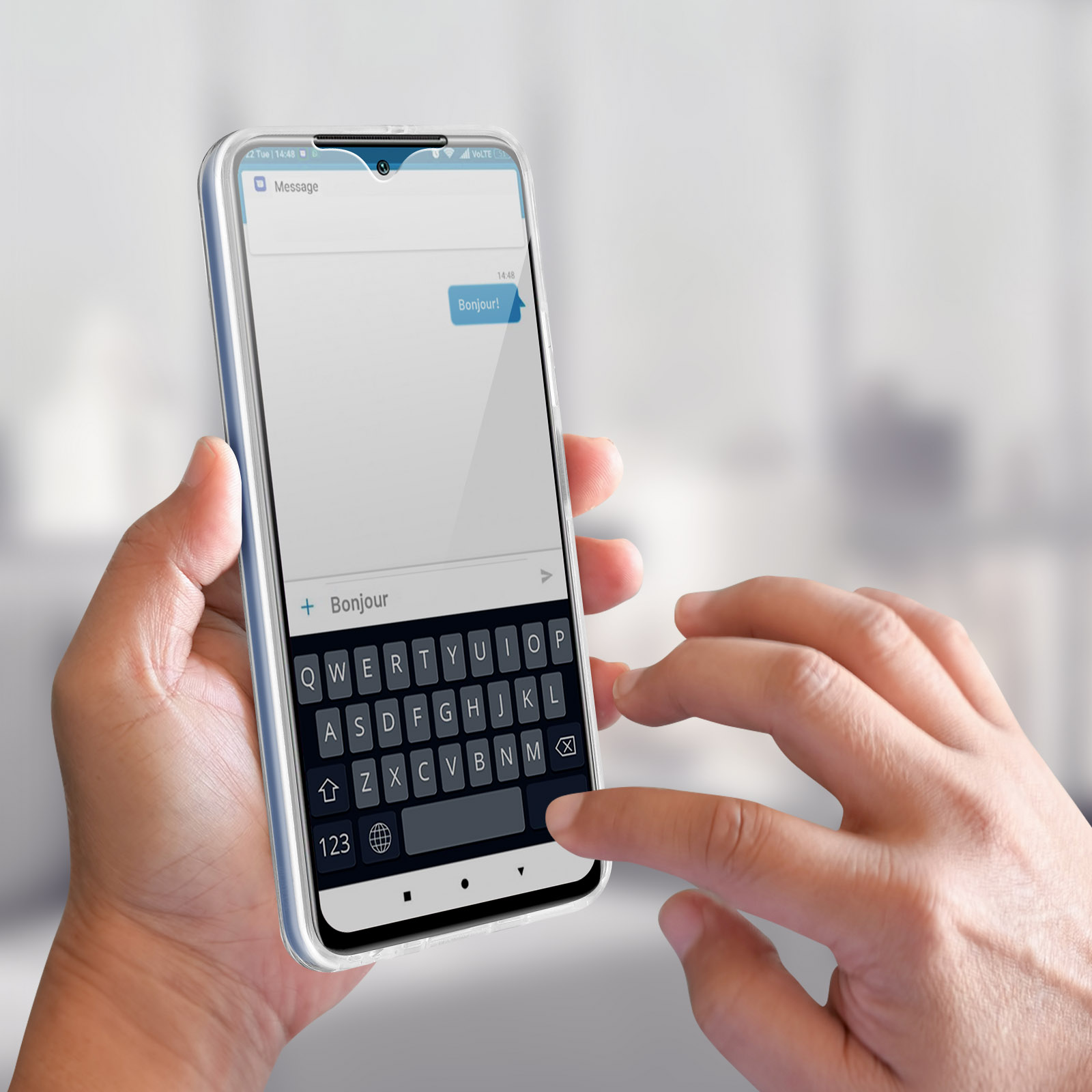 Mani di una persona che usa un telefono con il messaggio 'Bonjour' sullo schermo.