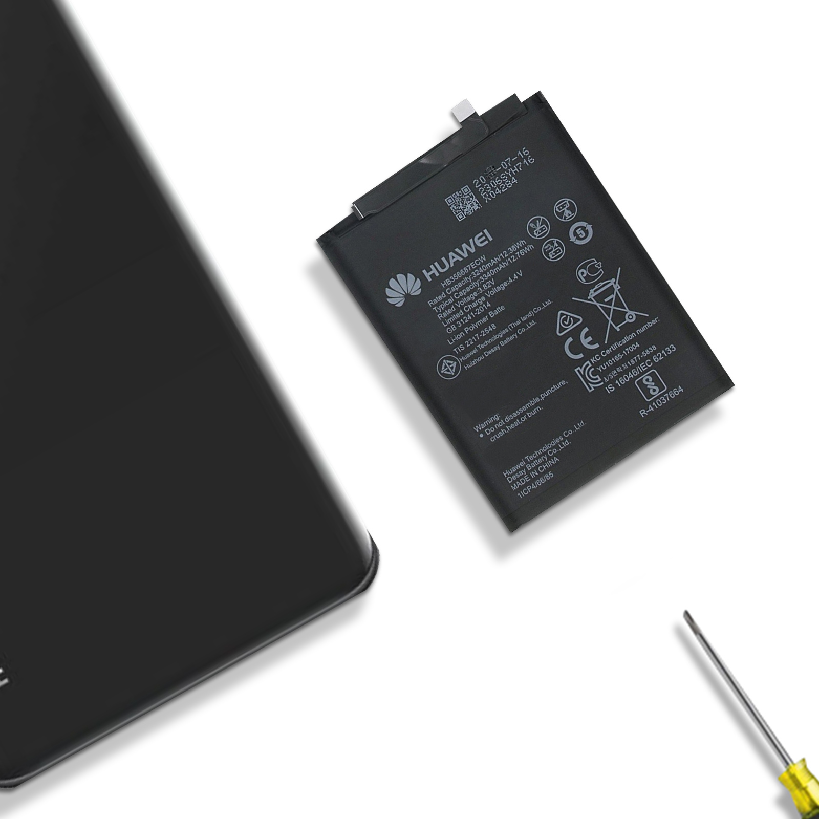 Una batería de teléfono negra con texto y logotipos, junto a un destornillador.