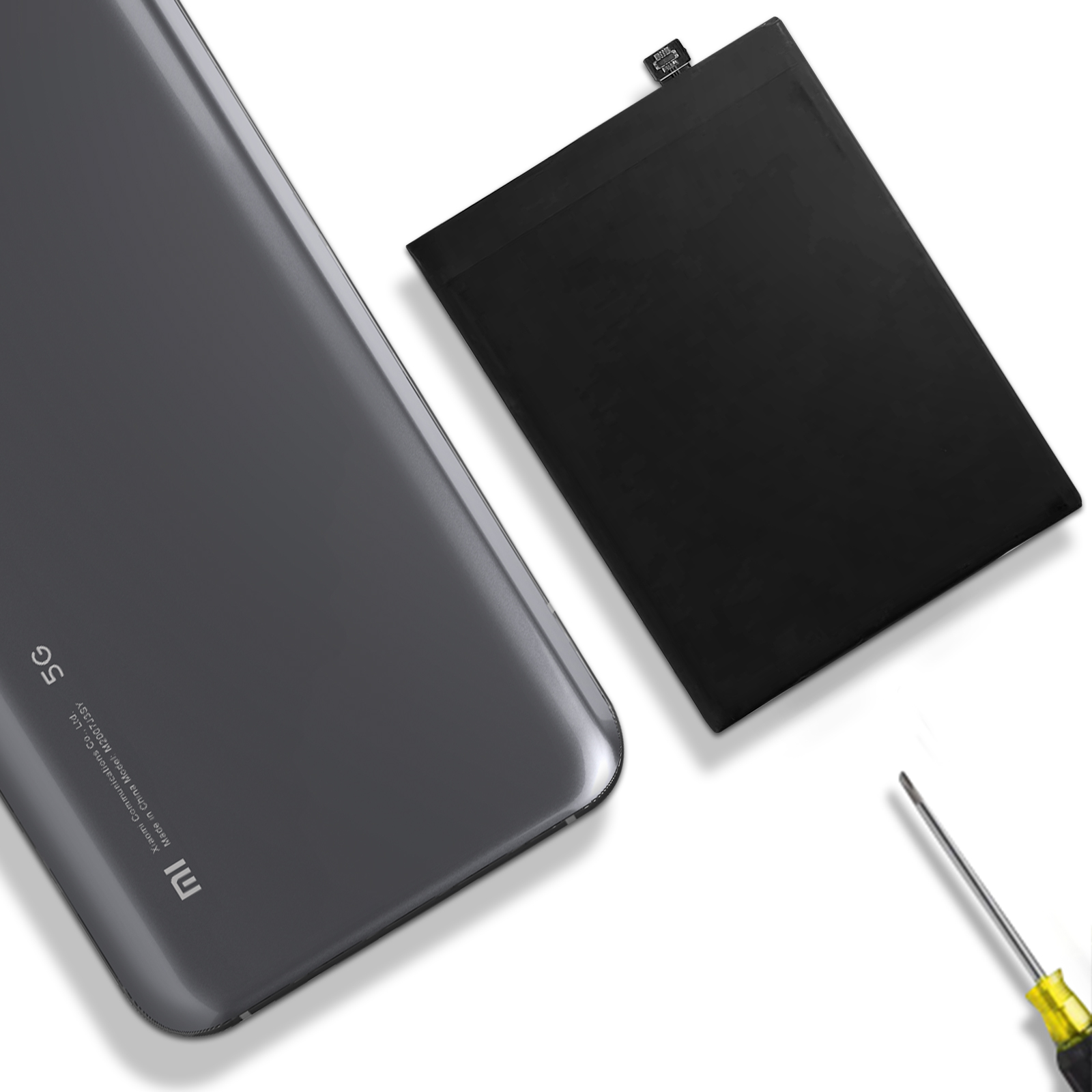 Batería de teléfono junto a un teléfono. Batería y teléfono negros sobre blanco.