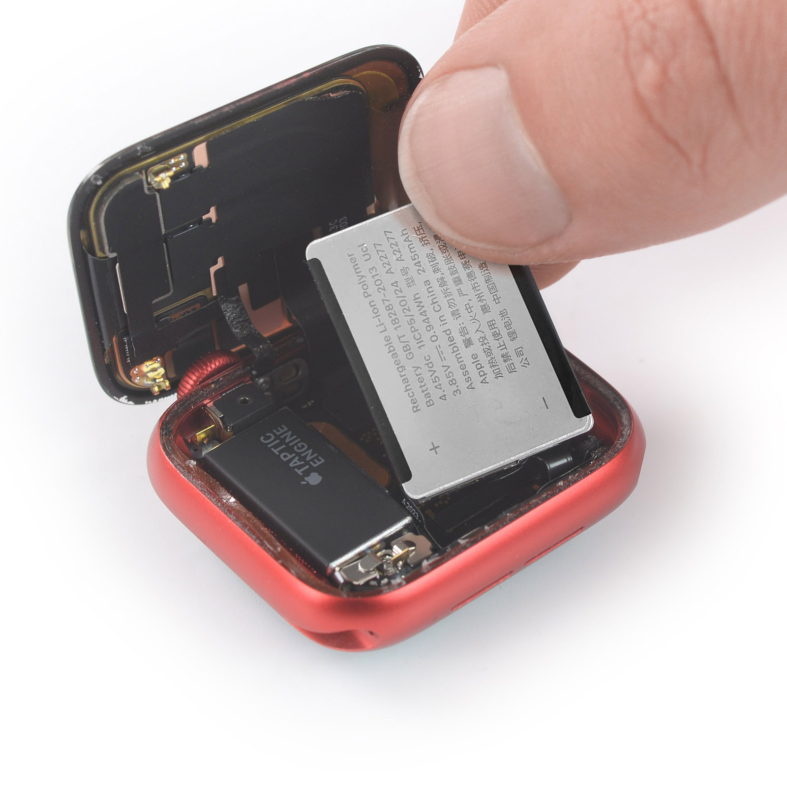 Eine offene Smartwatch. Eine Hand entfernt den Akku aus dem Inneren der Uhr.