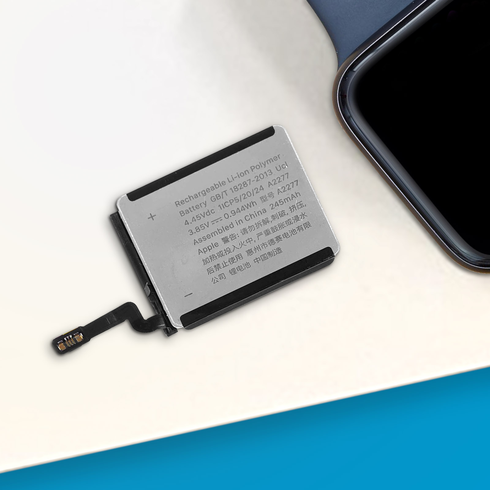 Eine Uhrenbatterie mit Text und Symbolen. Die Batterie befindet sich auf einer blau-weißen Oberfläche.