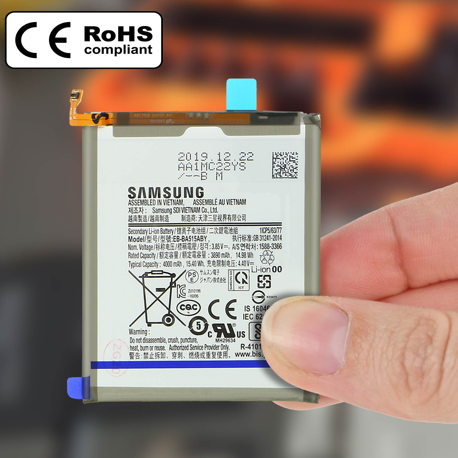 Una batteria per telefono Samsung tenuta in mano. Ha etichette, avvertenze e un logo conforme CE e RoHS.
