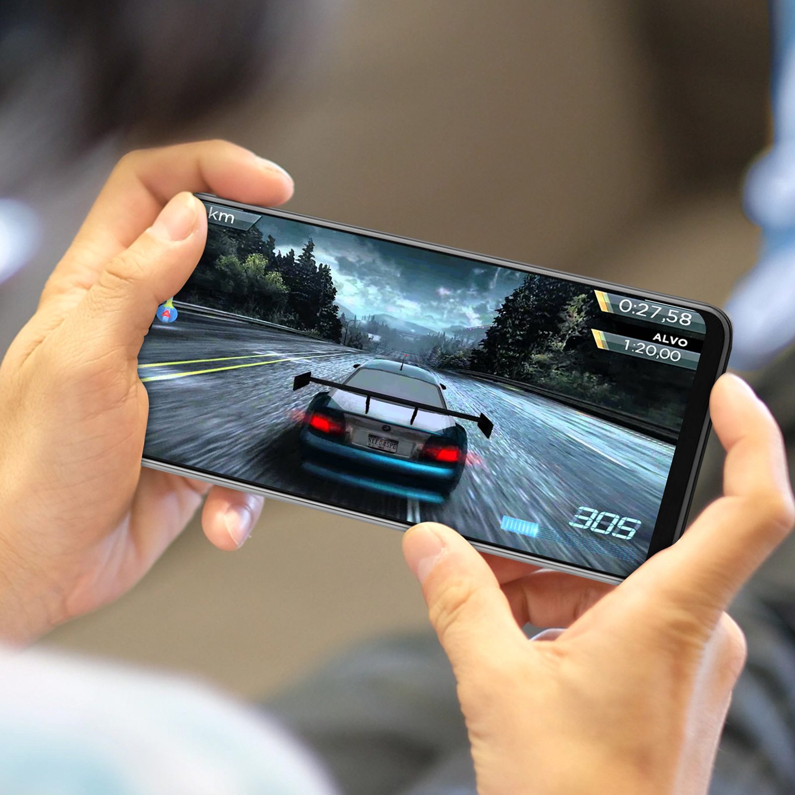 Mains tenant un téléphone jouant à un jeu de course. La voiture est au centre de l'écran.