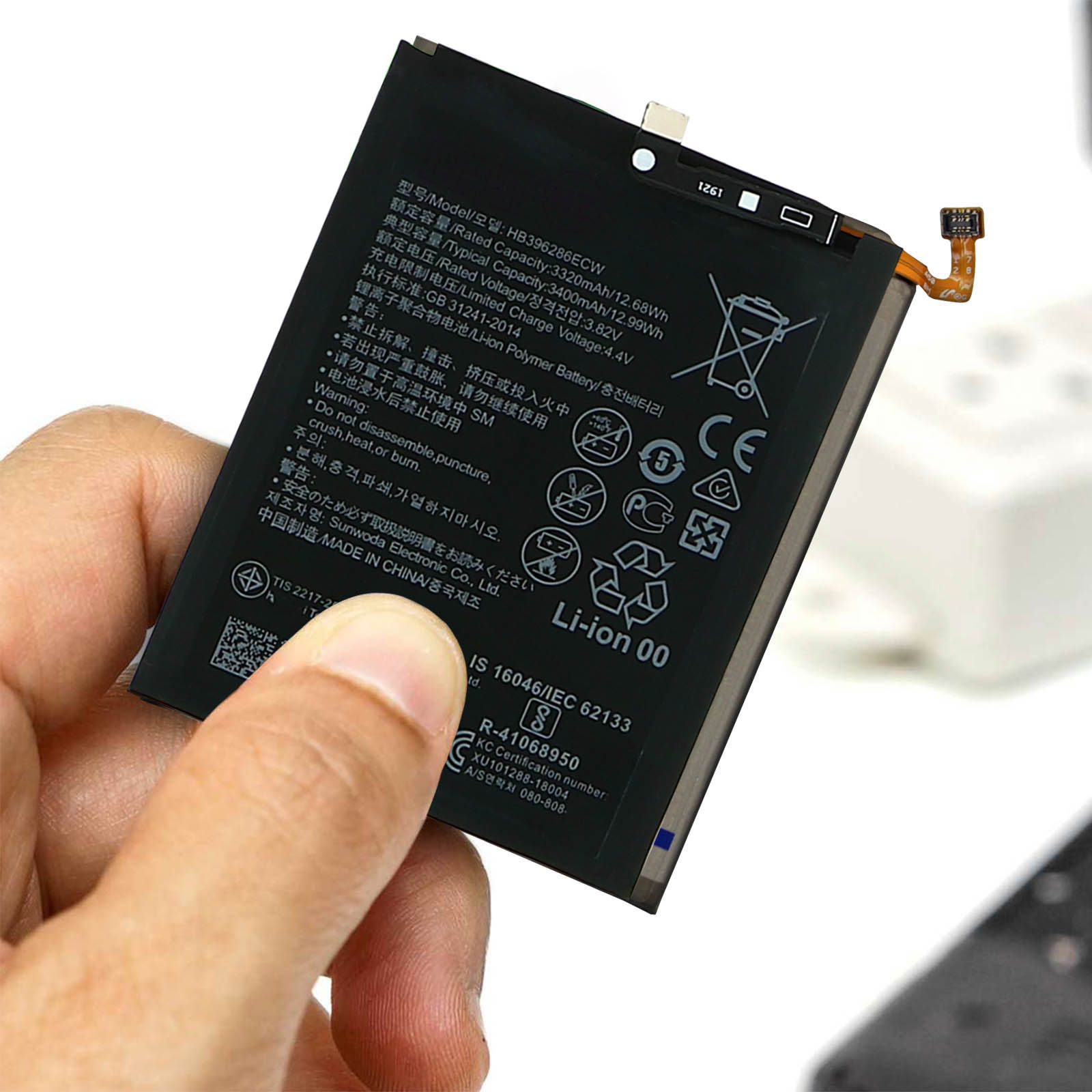Mano che tiene una batteria del telefono con testo.