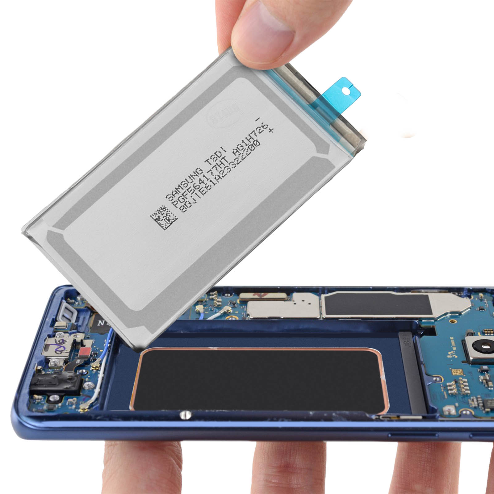 Batteria del telefono che viene inserita nel telefono. Mano che tiene la batteria. Cornice blu del telefono.