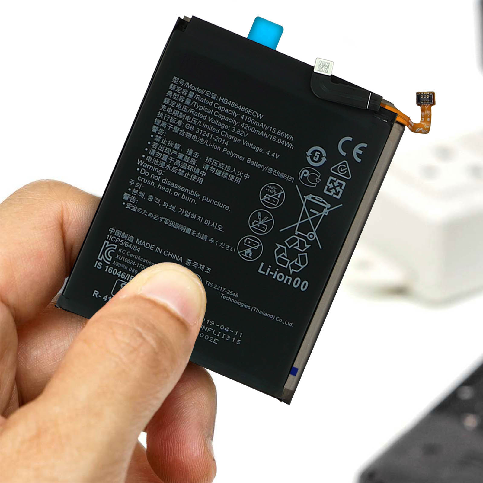 Mano che tiene una batteria del telefono con testo e simboli. Sfondo bianco.