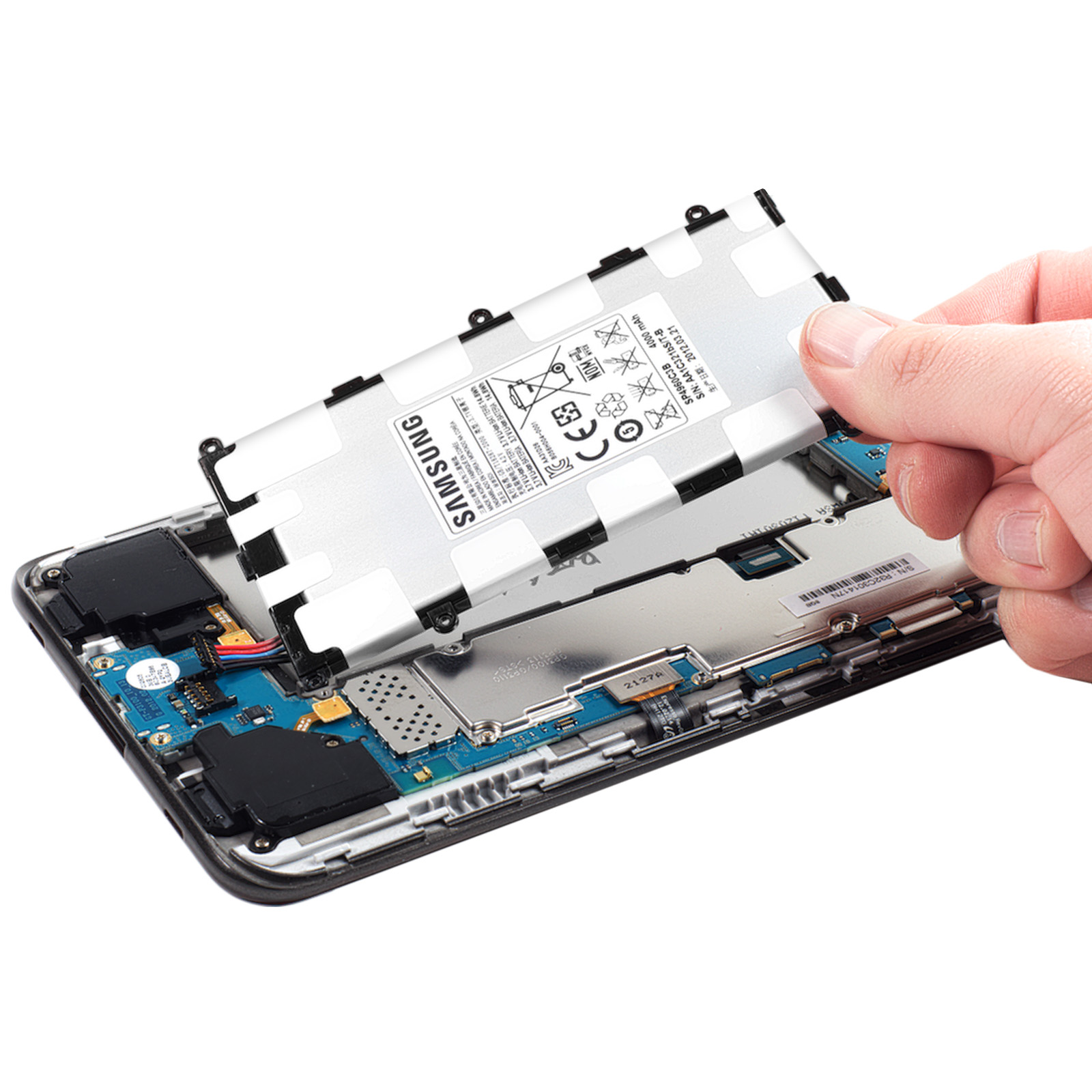 Mano quitando la batería del teléfono. La batería es plateada, y partes del teléfono son visibles.