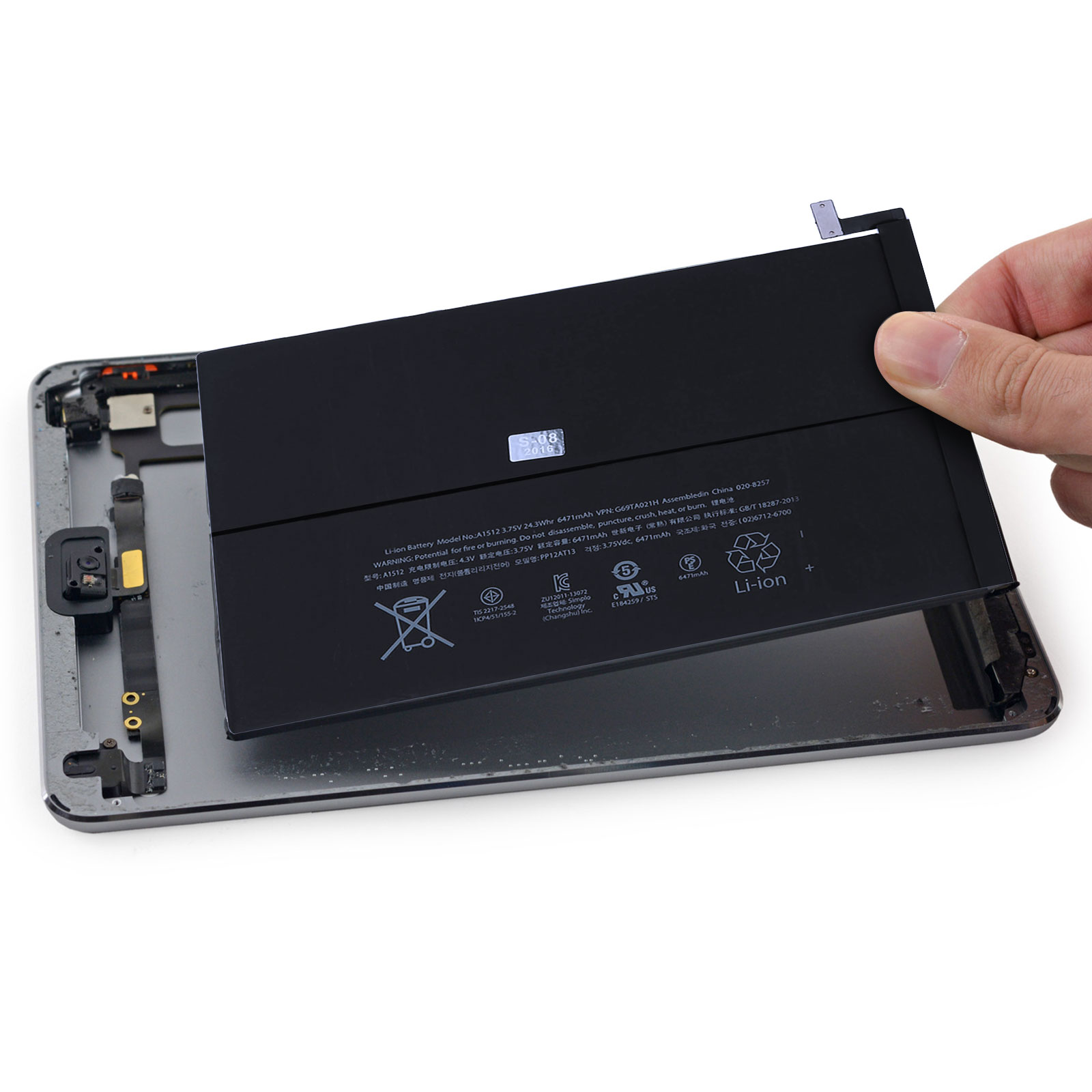 Mano che rimuove una batteria del telefono da un tablet, interno visibile.