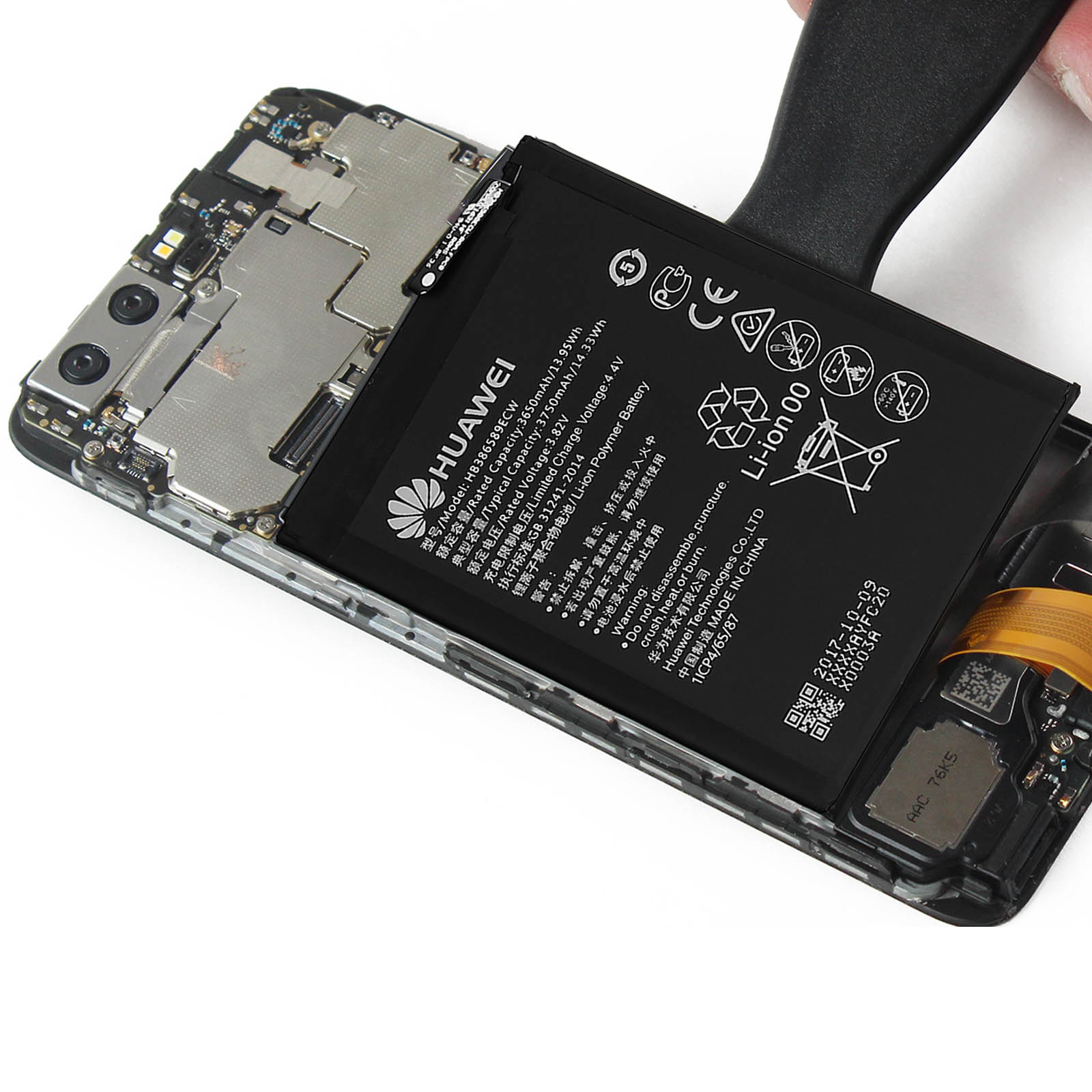 Telefon mit entfernter Batterie, Huawei-Logo sichtbar, mit einem Werkzeug.