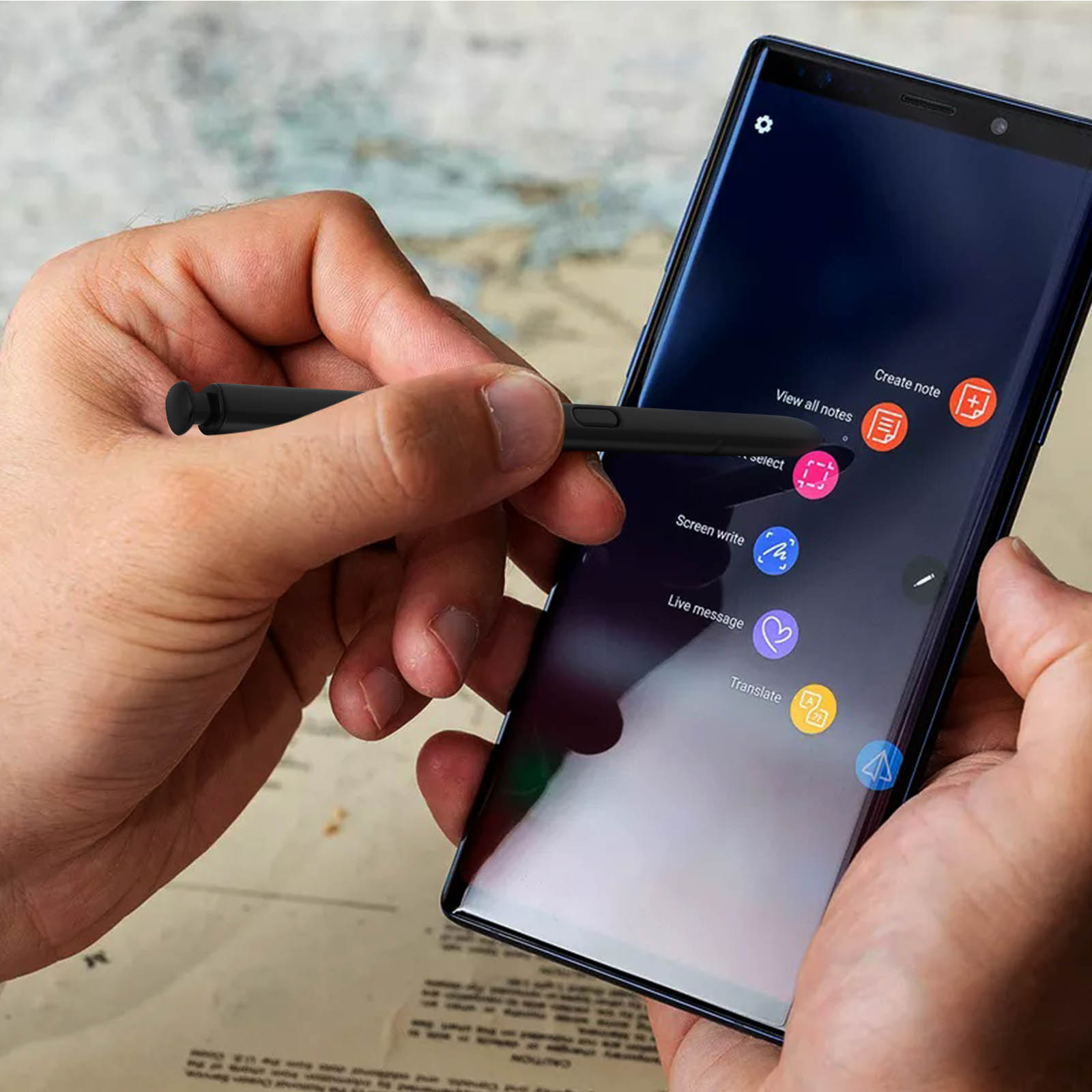 Hand, die einen Stift über einem Telefon mit verschiedenen App-Symbolen hält.