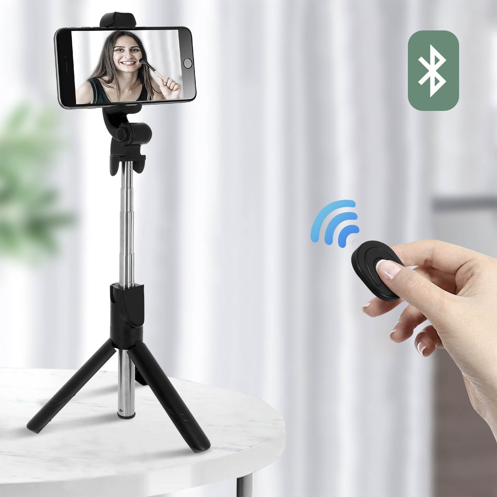 Una donna tiene un telecomando vicino a un selfie stick con un telefono. Un simbolo Bluetooth è visibile.