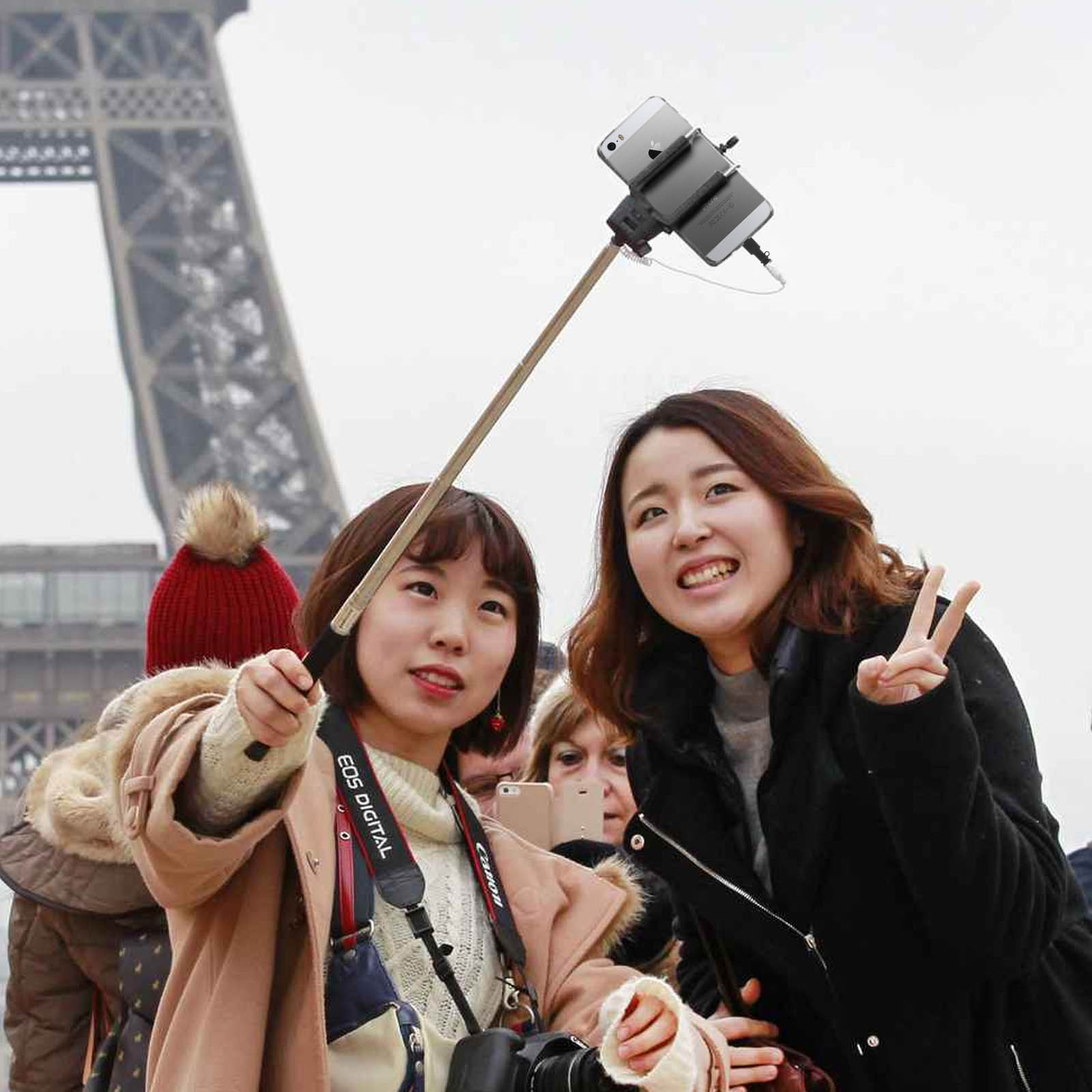 Dos mujeres tomando un selfie con un palo selfie frente a la Torre Eiffel, París.