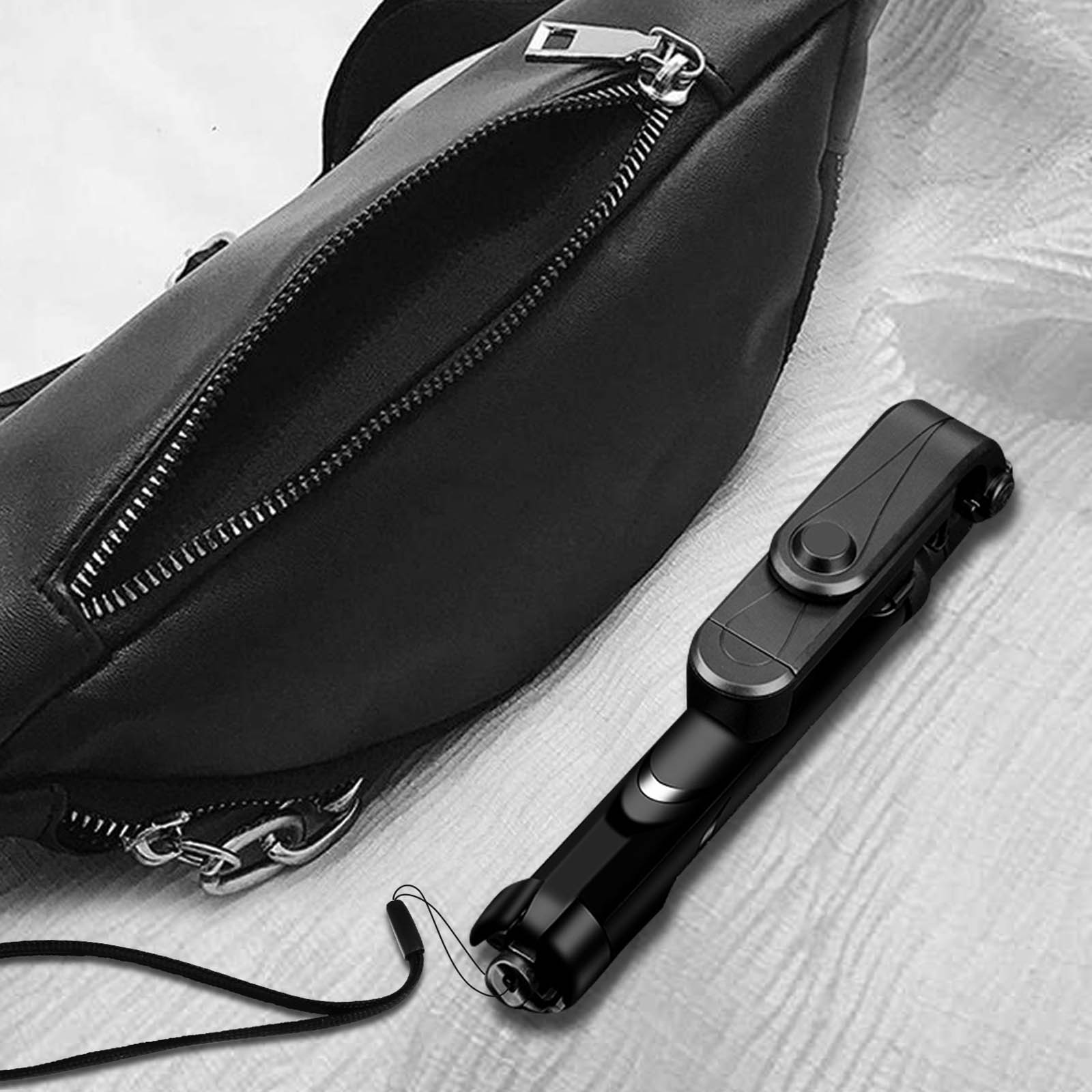 Eine schwarze Tasche mit Reißverschluss und ein schwarzer Selfie-Stick.